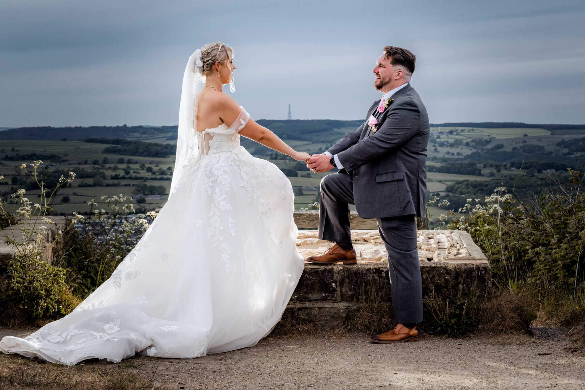 Bride and groom holding hands with panoramic valley views at Surprise View.
