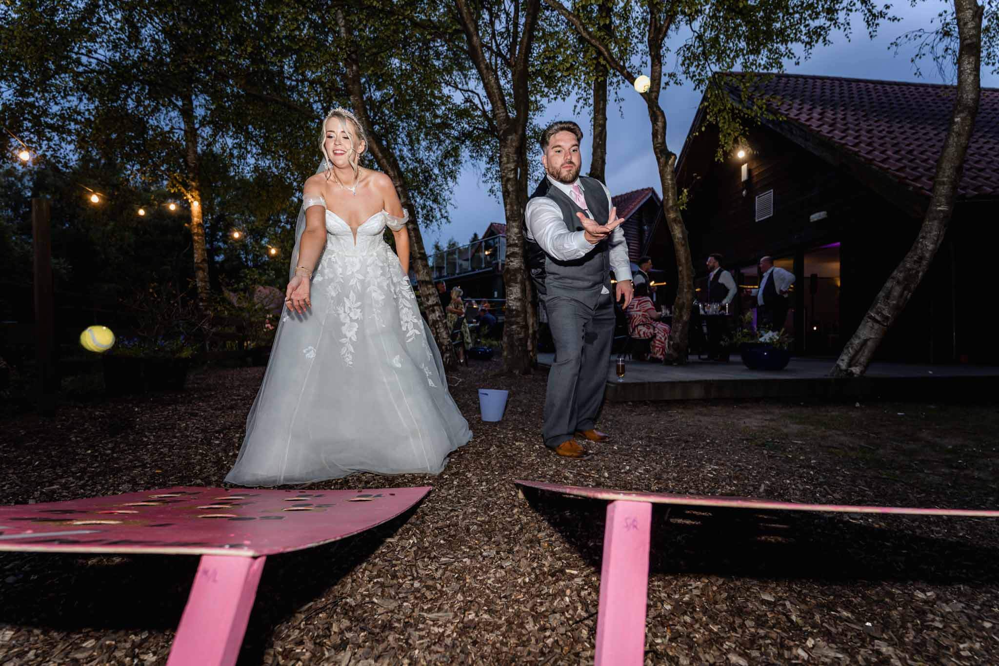 Bride and groom playing an outdoor game during wedding reception.