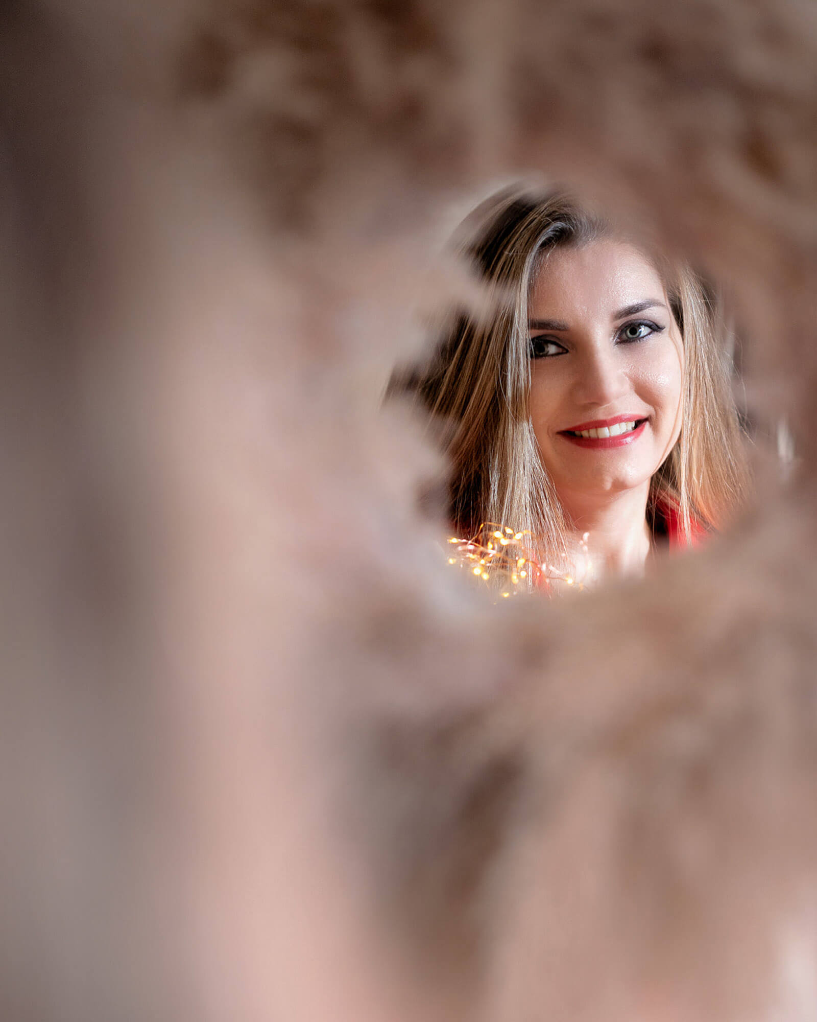 Artistic behind-the-scenes portrait with bokeh lights during Christmas studio photo session in Leeds.