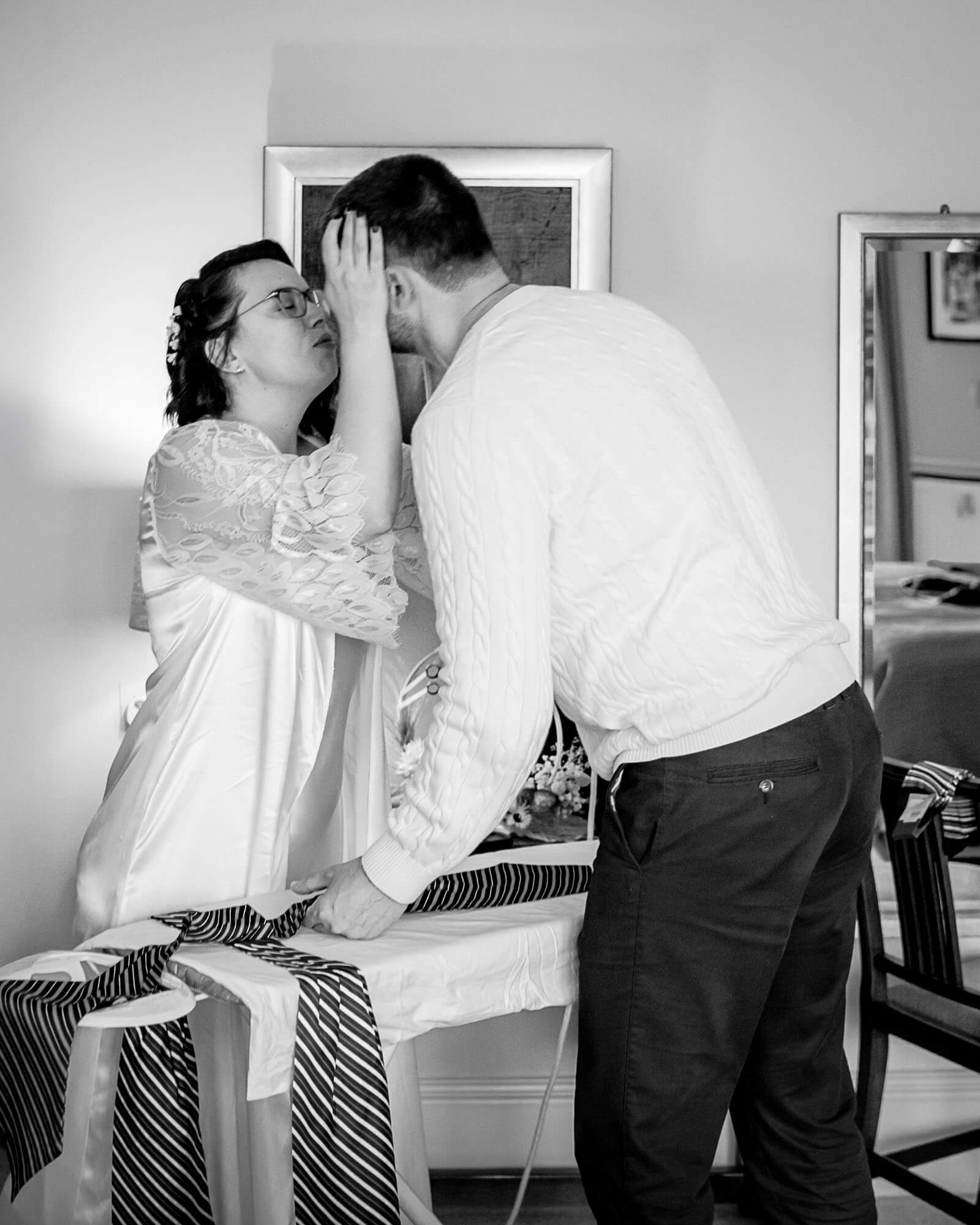 Intimate elopement wedding moment in Yorkshire as the couple share a quiet, emotional kiss during morning preparations.