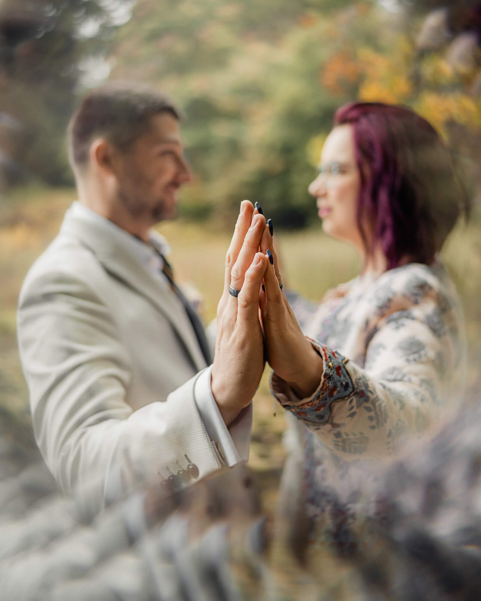 Intimate elopement wedding in Yorkshire as the couple touch hands in a quiet, emotional moment outdoors.