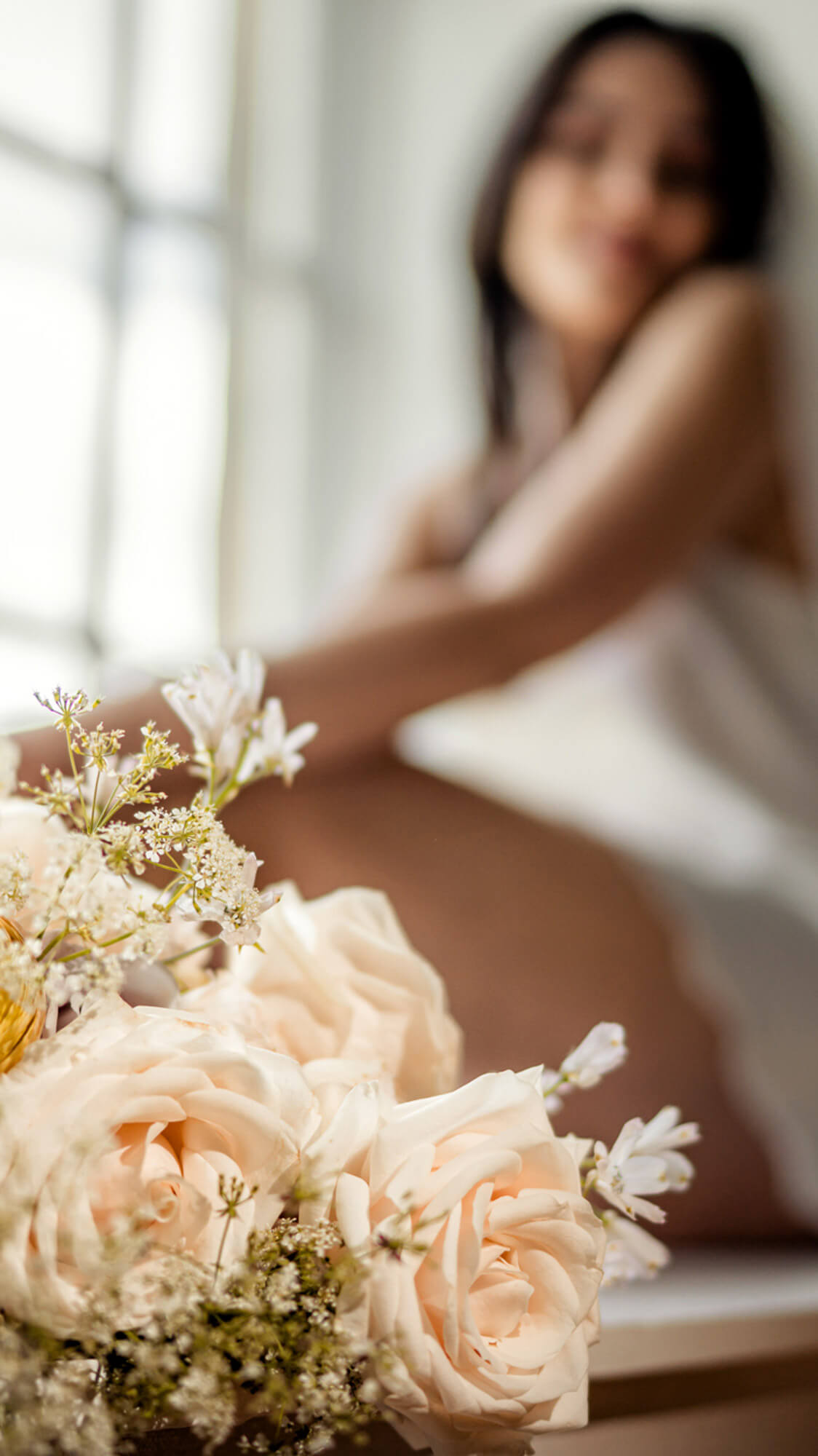 Soft bridal bouquet detail with bride blurred in background