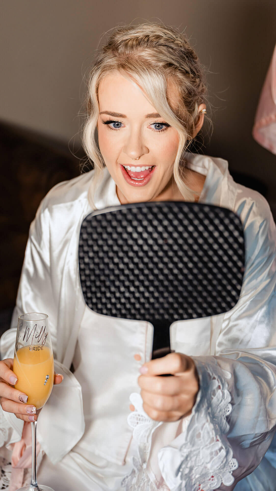 Bride getting ready while looking in mirror before wedding ceremony