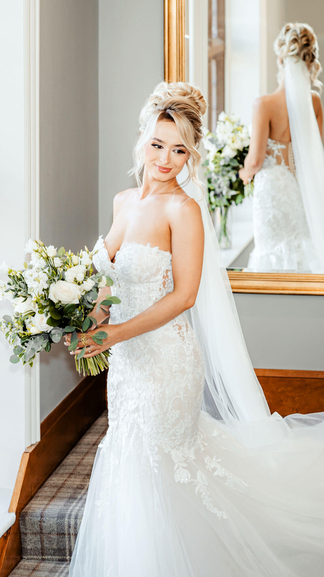 Editorial bridal portrait of bride holding bouquet in soft window light