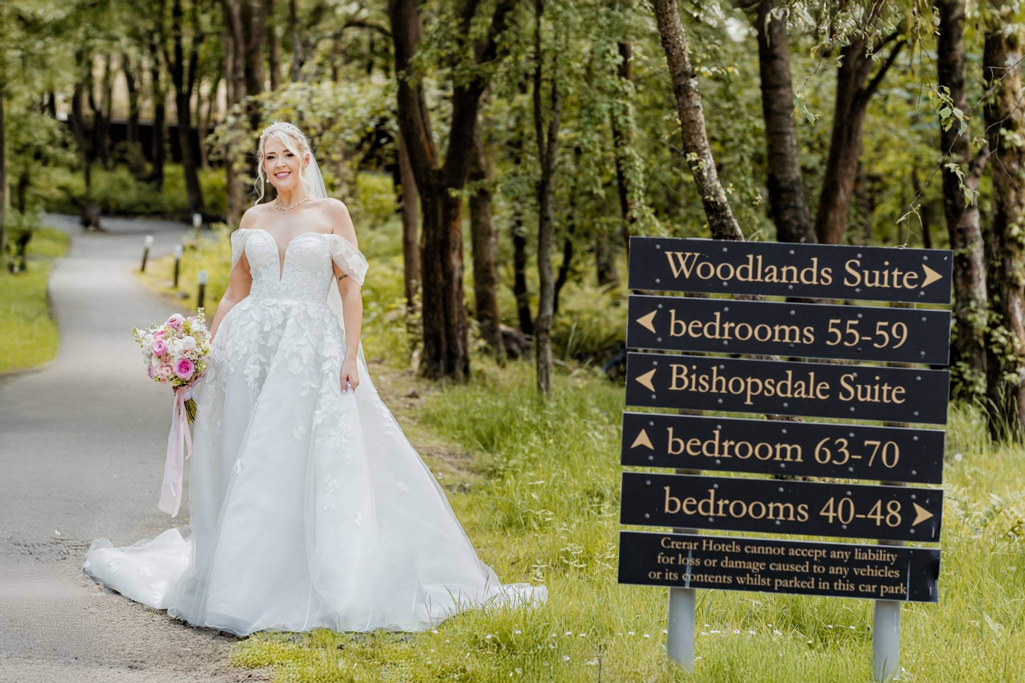 Editorial bridal portrait of bride holding bouquet near Woodland Suite sign at Hazlewood Castle in Yorkshire