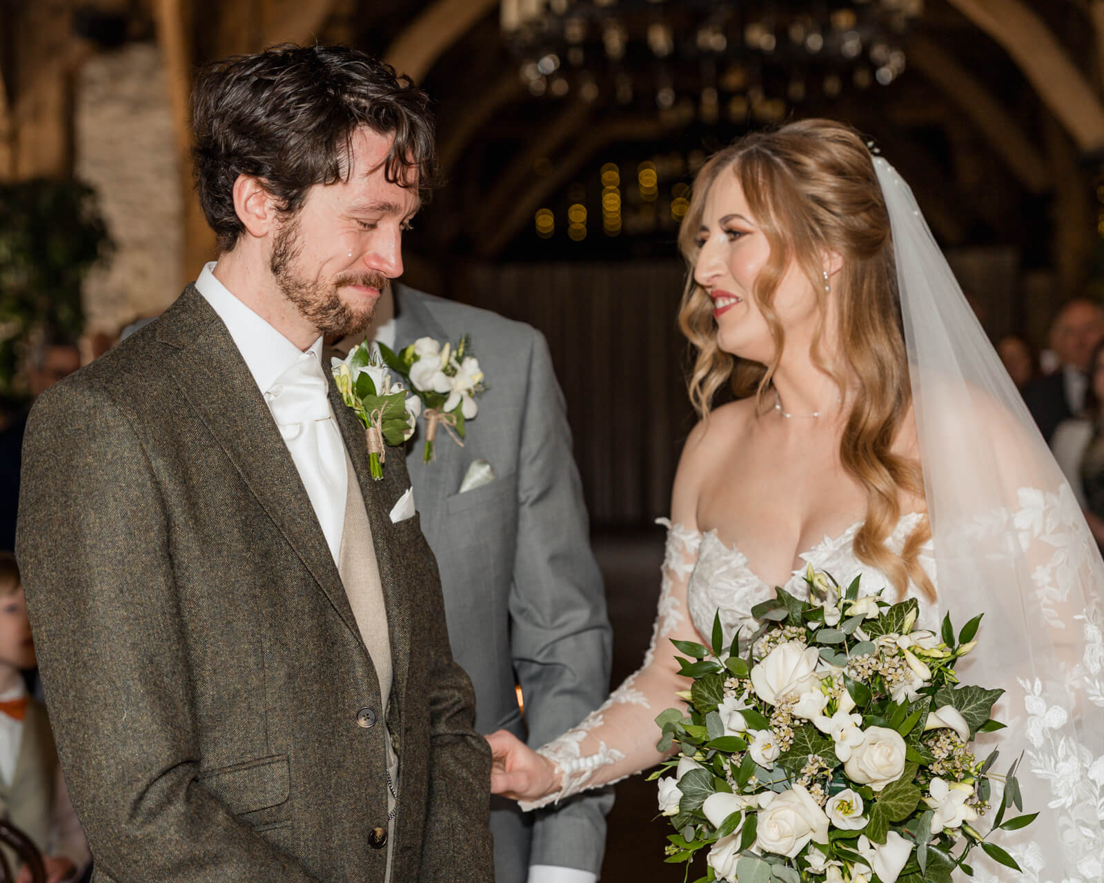 Emotional groom reacting as bride arrives at the altar during wedding ceremony