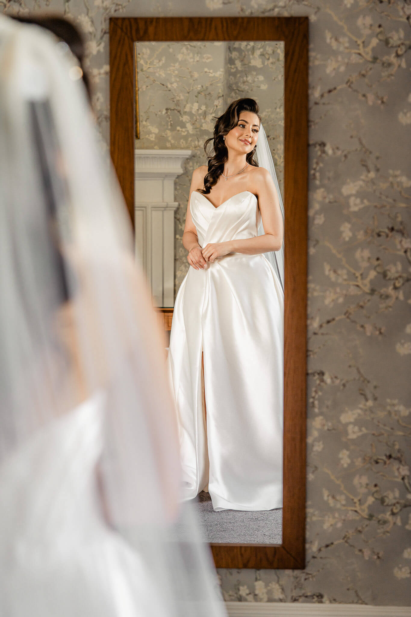 Bride standing in front of a mirror during editorial bridal portraits at Hazlewood Castle