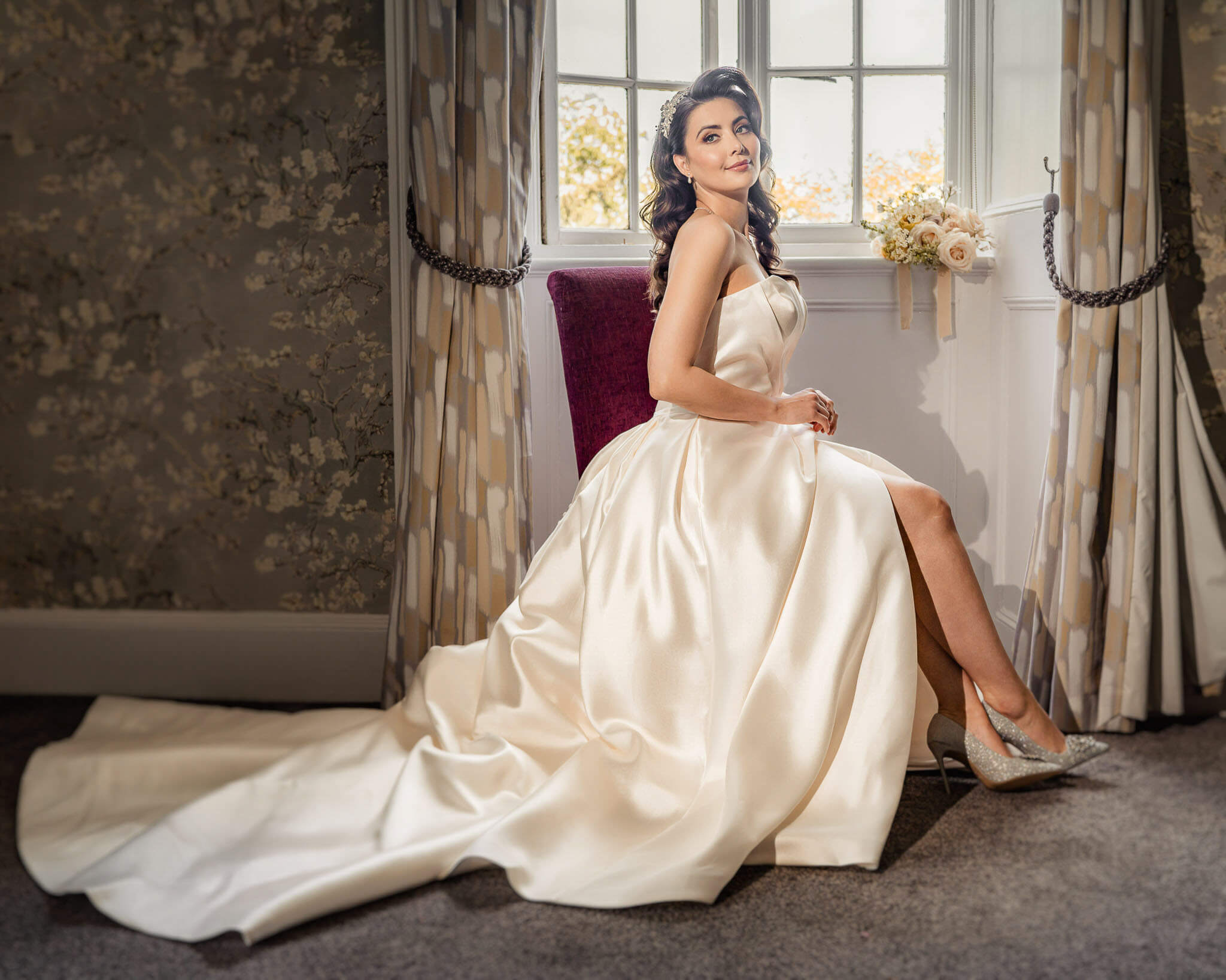 Bride seated by a window in her wedding gown during Hazlewood Castle bridal portraits