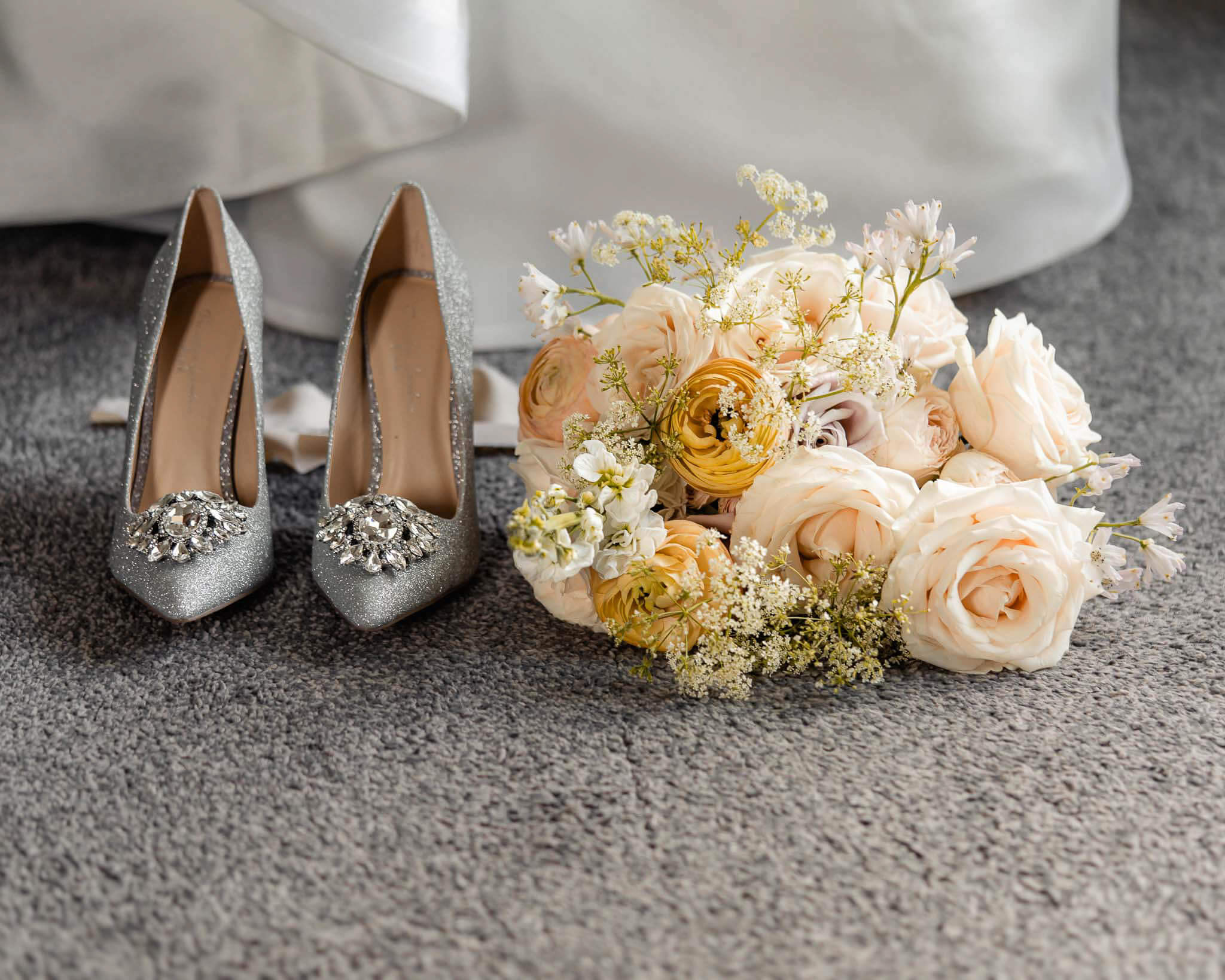 Bridal shoes and bouquet arranged on the floor during Hazlewood Castle wedding preparations