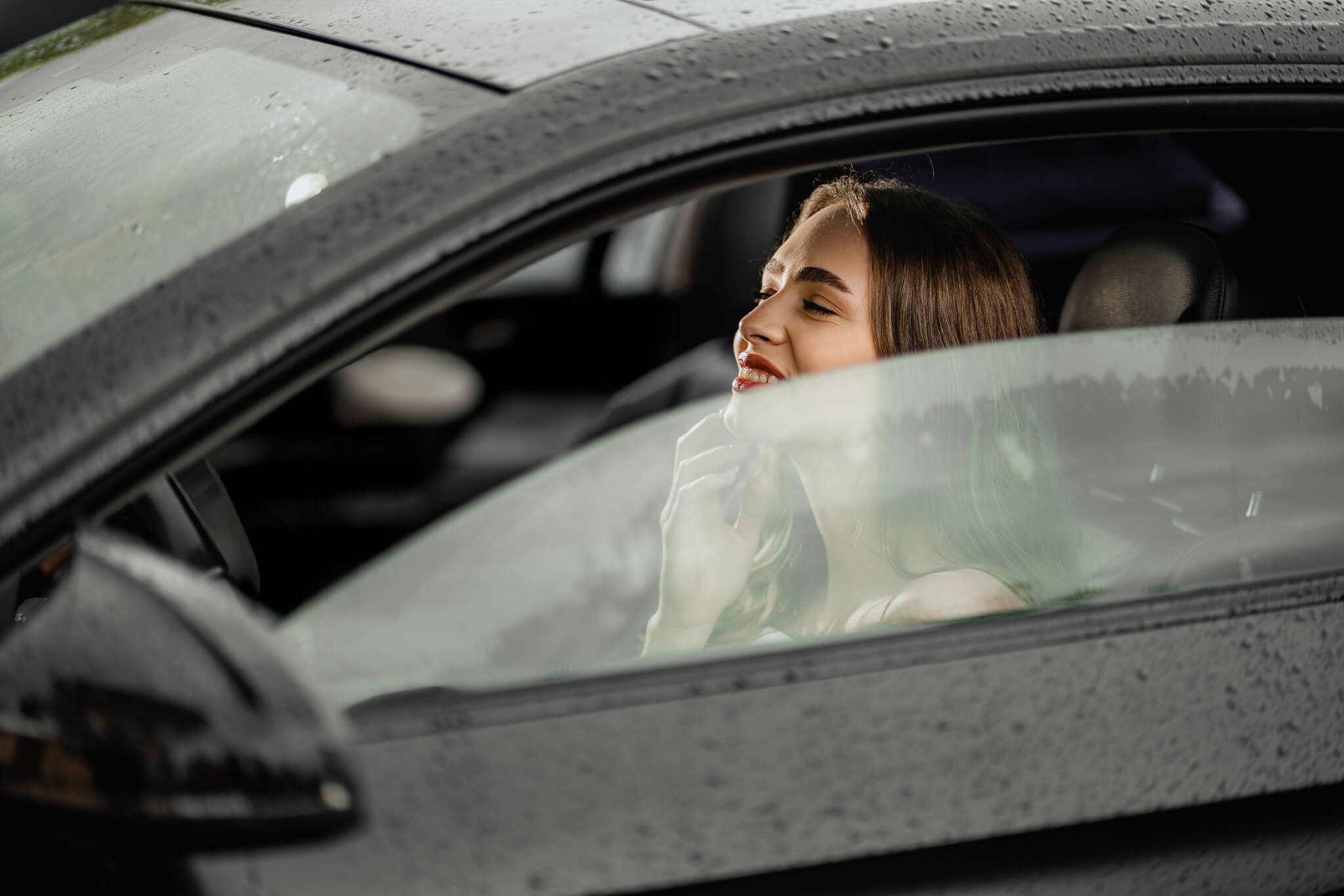 modern bridal inspiration candid portrait inside car with rain droplets on window