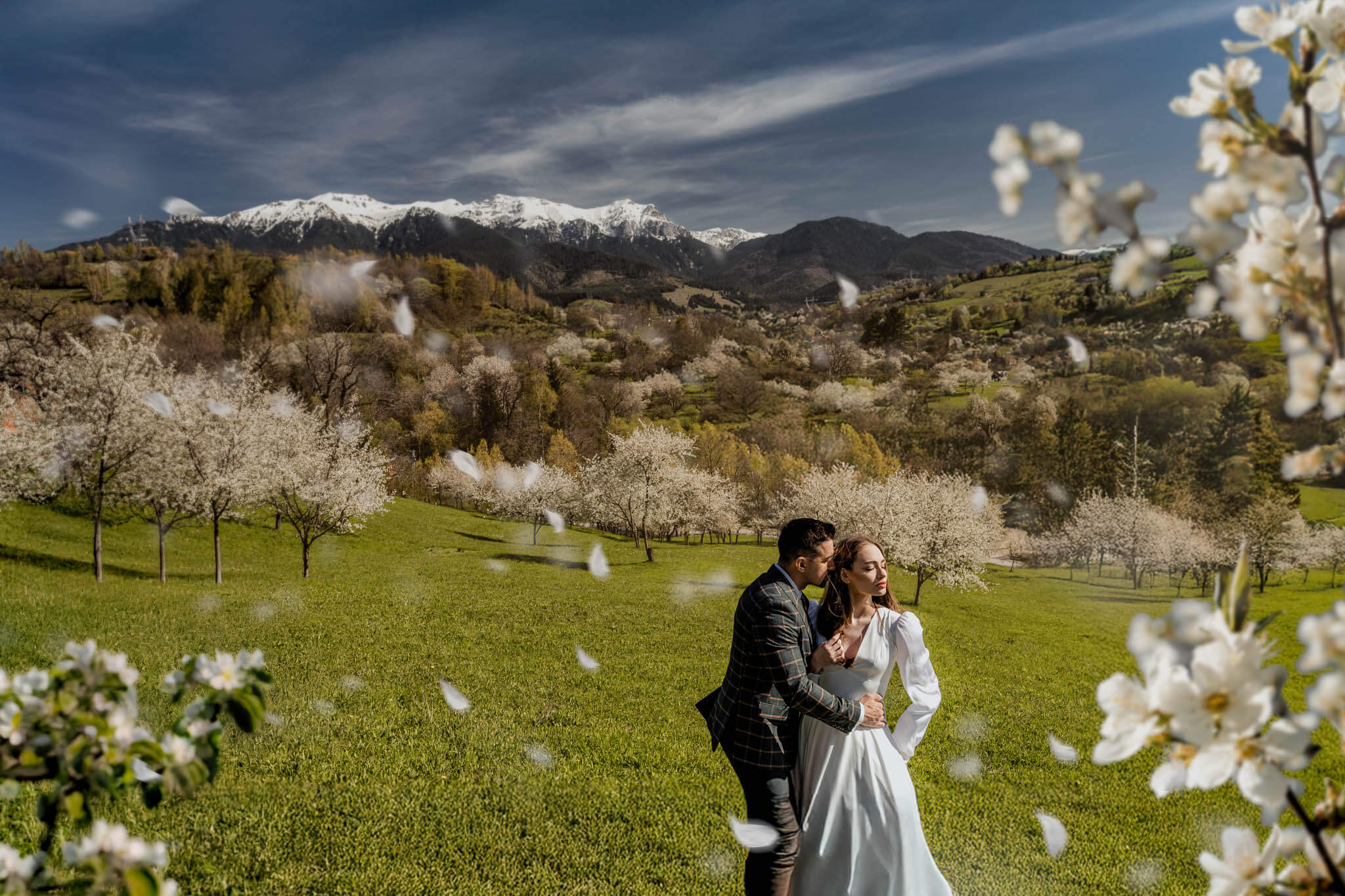 romantic spring wedding couple portrait with mountains and blossom trees