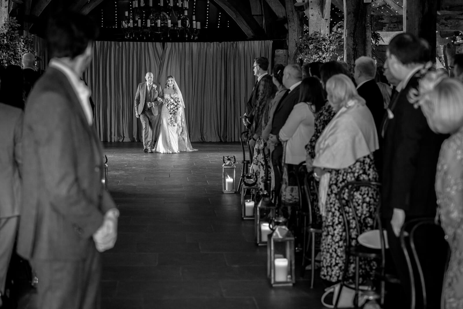 Bride walking down the aisle with her father at The Tithe Barn at Bolton Abbey