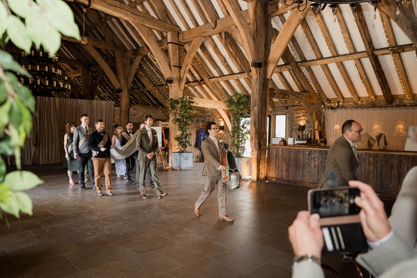 Groom and wedding party walking into ceremony at The Tithe Barn at Bolton Abbey