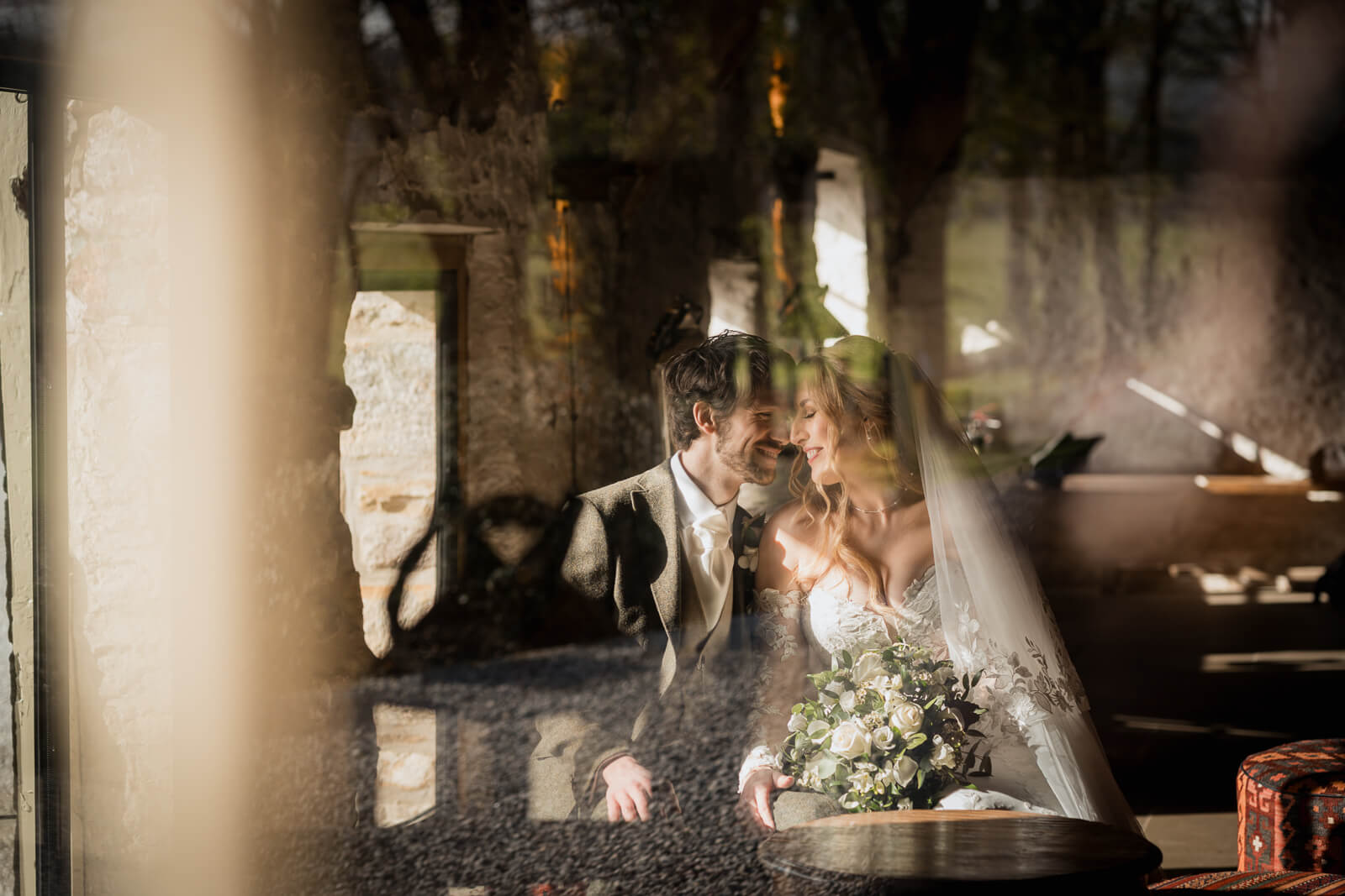 Creative reflection portrait of a bride and groom sharing a quiet moment inside a rustic barn venue