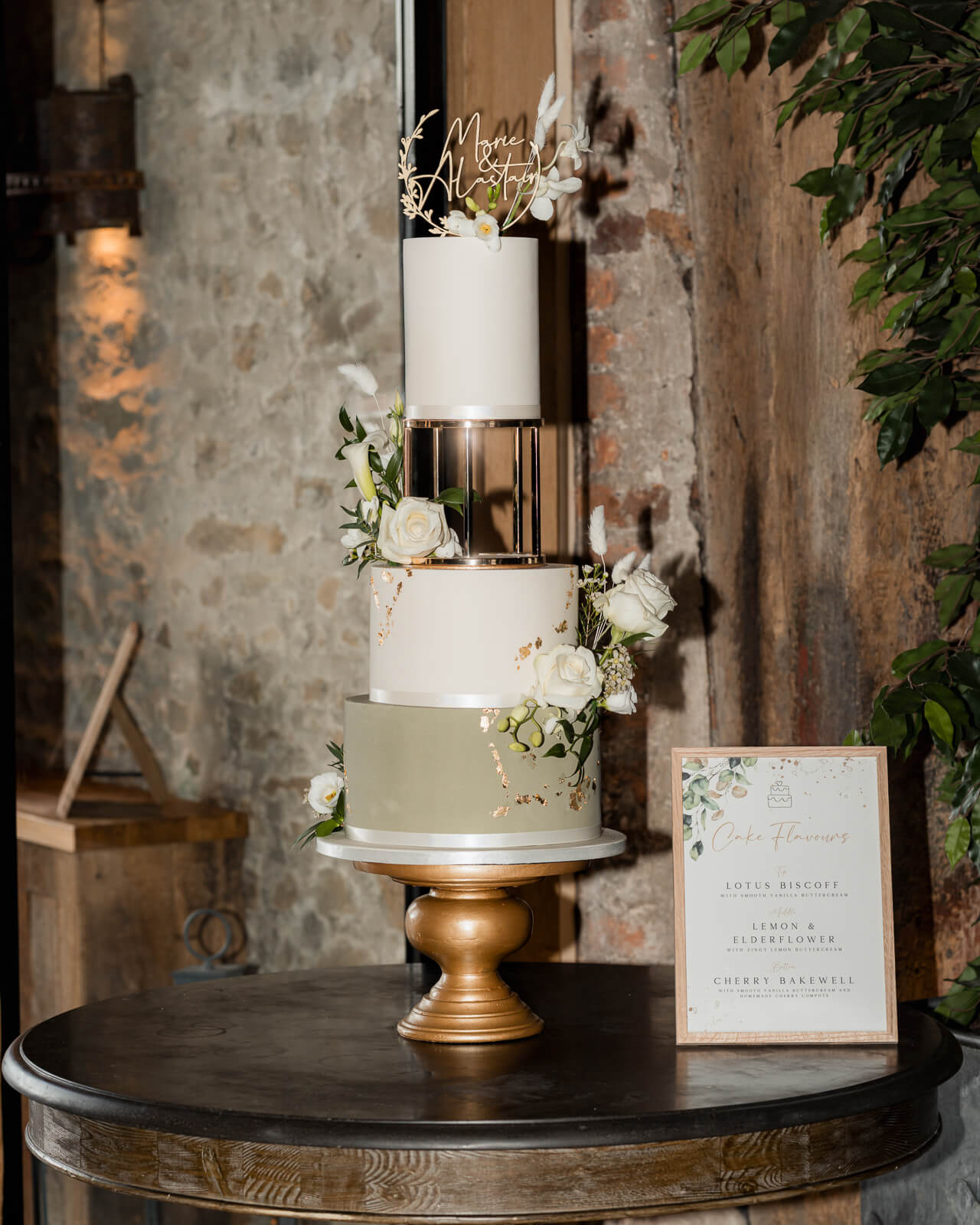 Elegant wedding cake display at The Tithe Barn at Bolton Abbey with floral details and gold accents