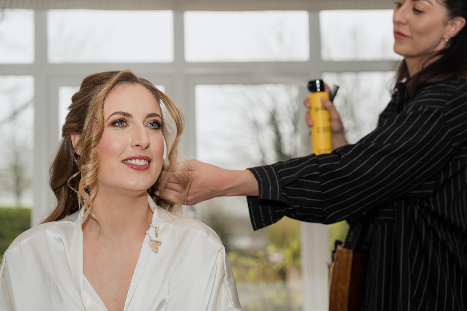 Bride getting hair styled during morning preparations at The Tithe Barn at Bolton Abbey