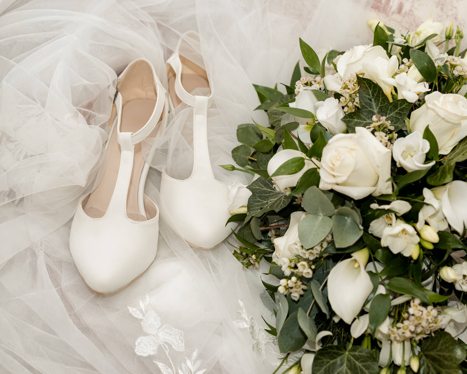 Bridal shoes and bouquet detail captured at The Tithe Barn at Bolton Abbey