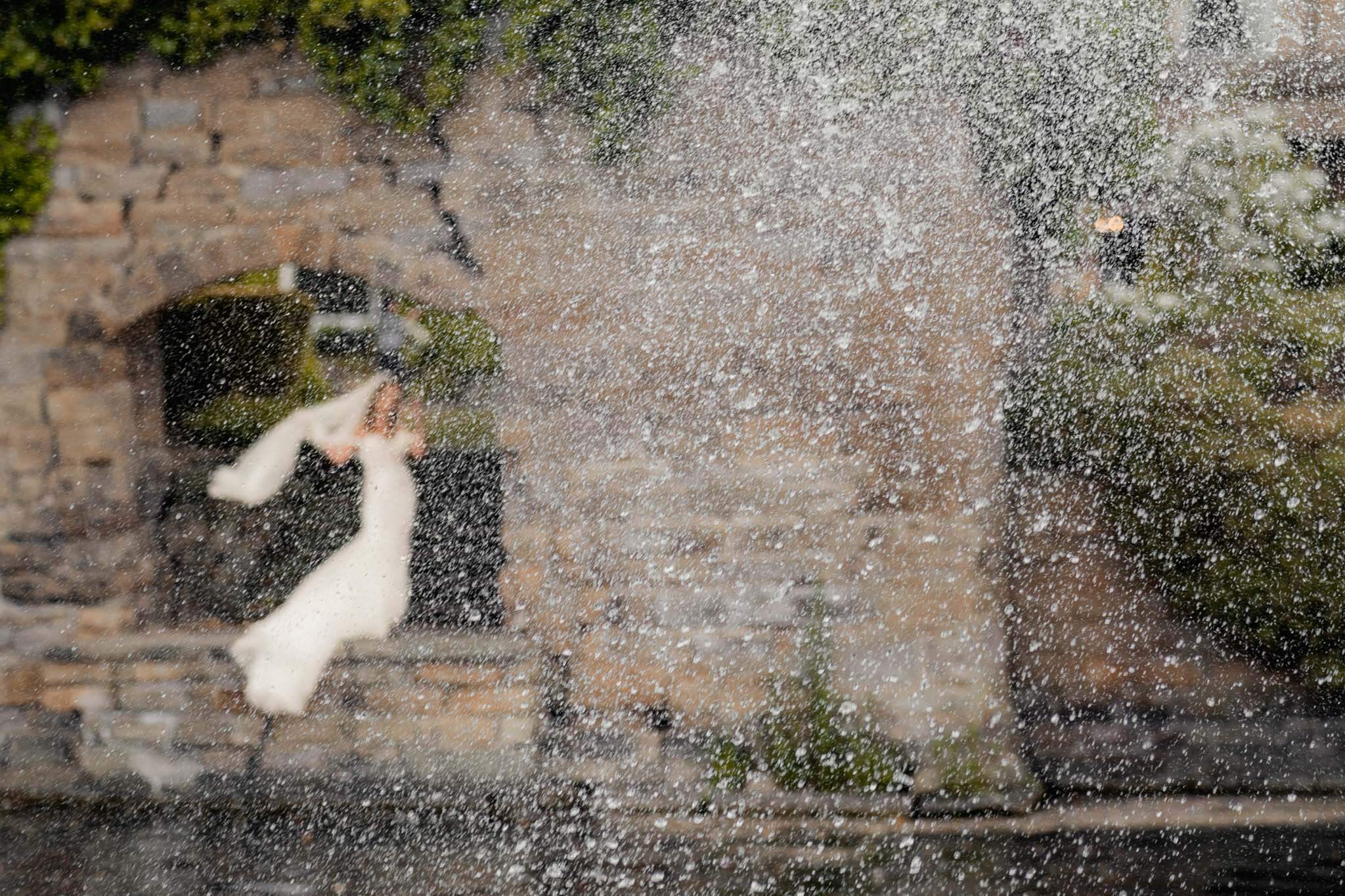 Waterton Park wedding photographer capturing artistic bridal portrait near waterfall and stone arch in Wakefield Yorkshire