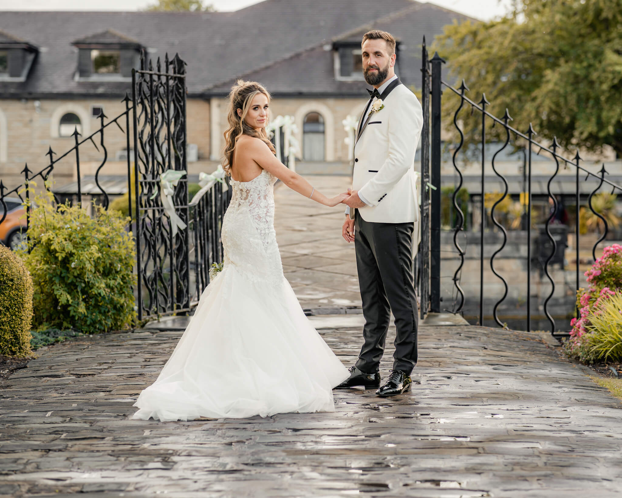 Bride and groom holding hands on stone bridge at Waterton Park Hotel