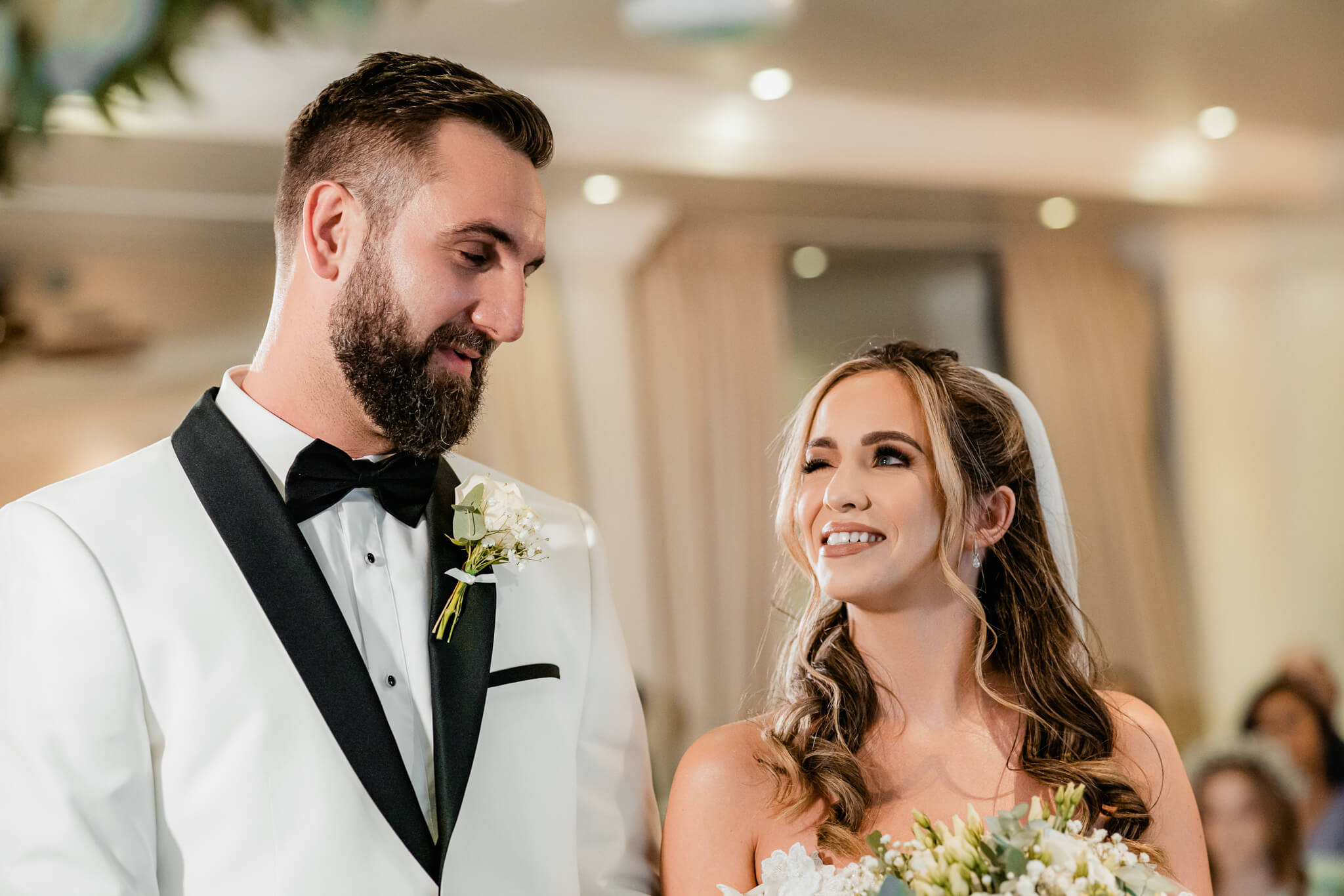 Bride smiling up at groom during wedding ceremony