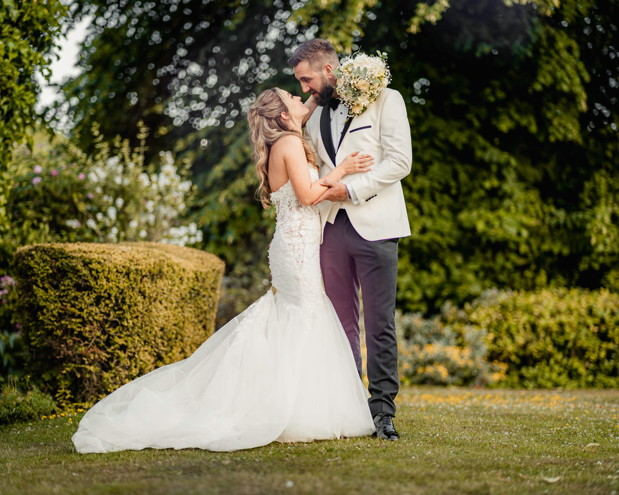 Bride and groom embracing in garden portrait at Waterton Park Hotel