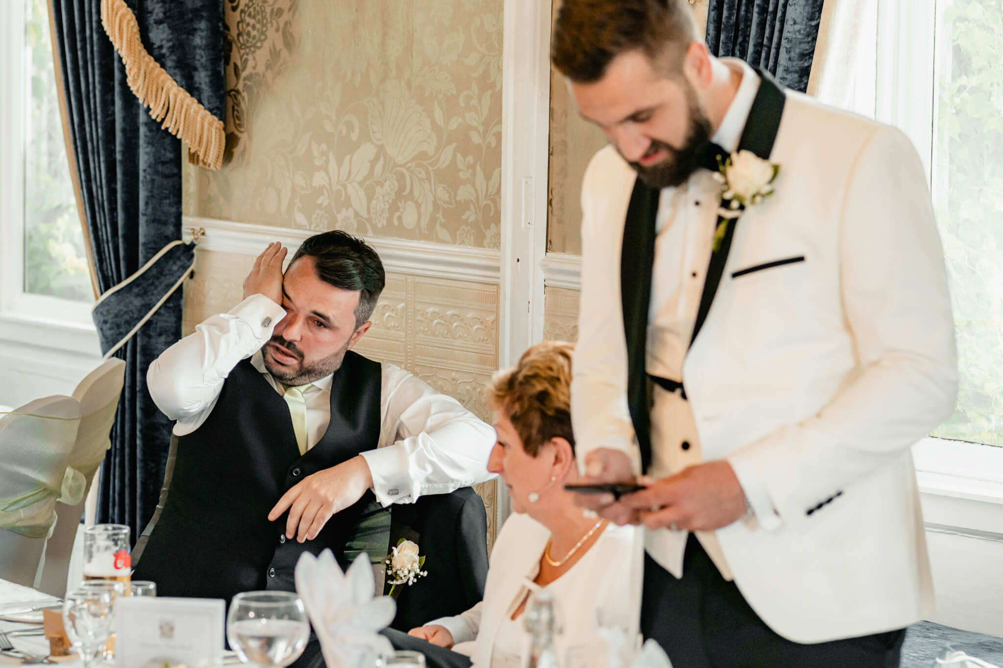 Guest wiping tears during emotional wedding speech
