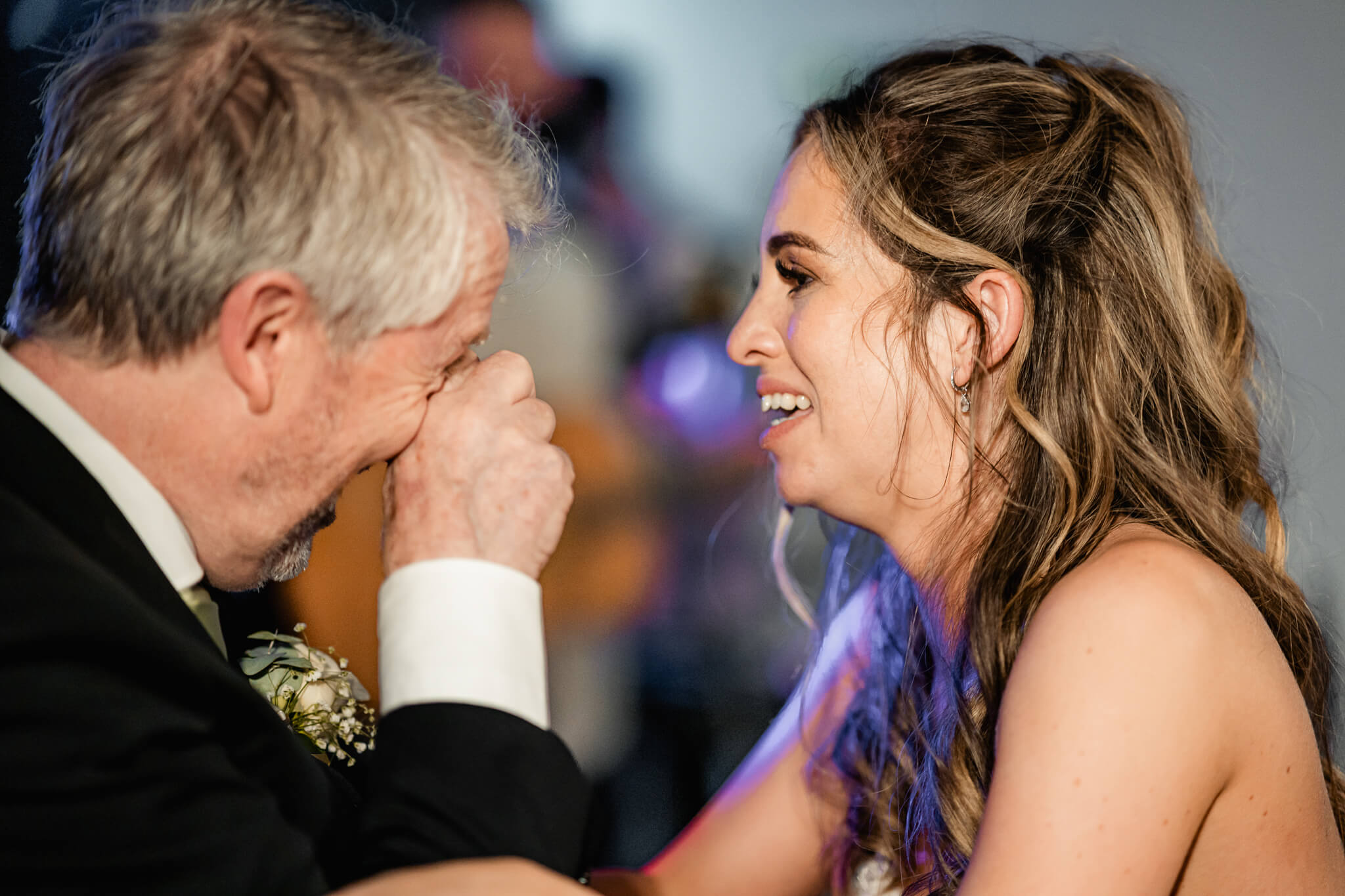 Father wiping tears while dancing with bride