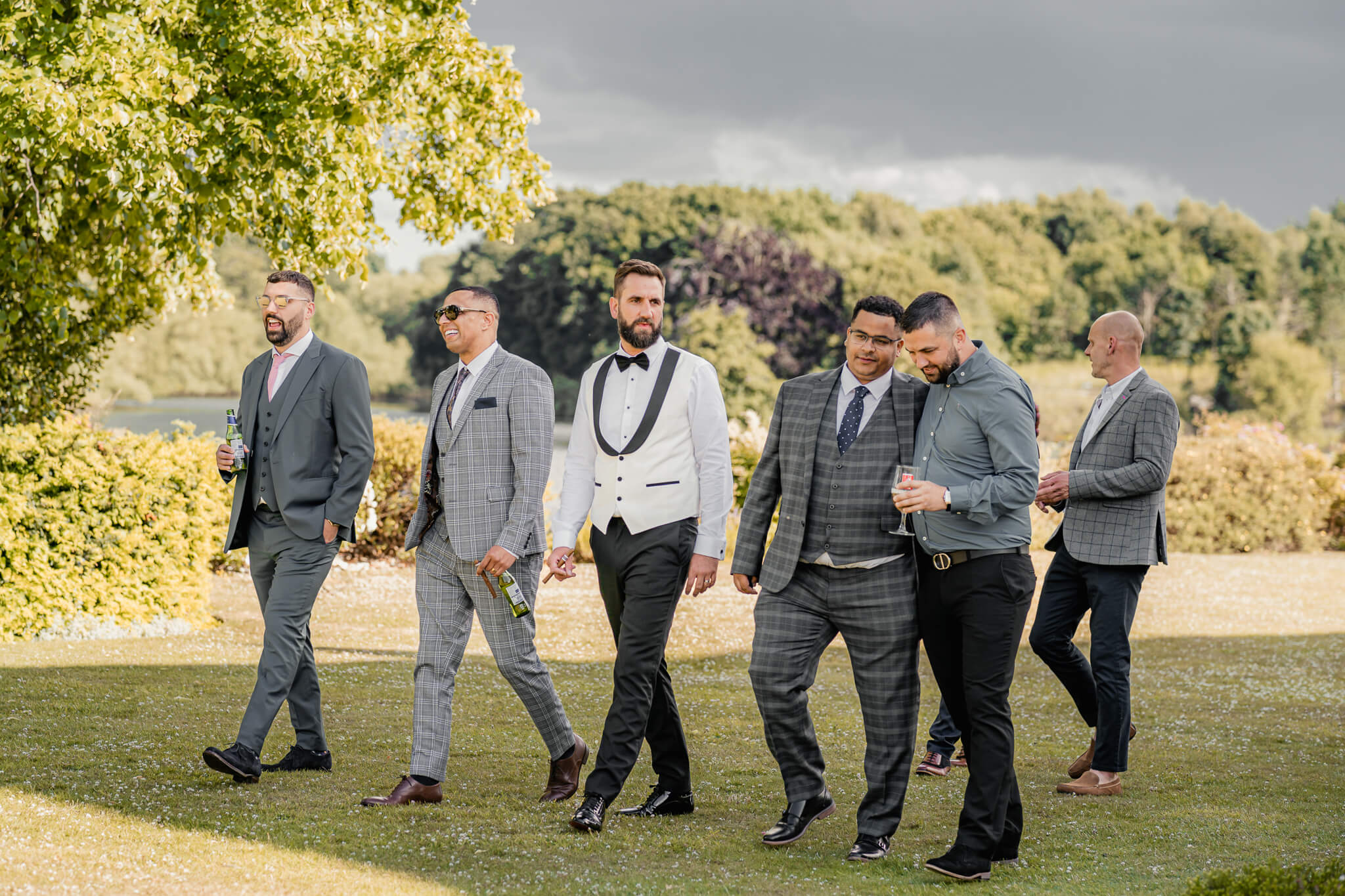 Groom walking with groomsmen outdoors before ceremony
