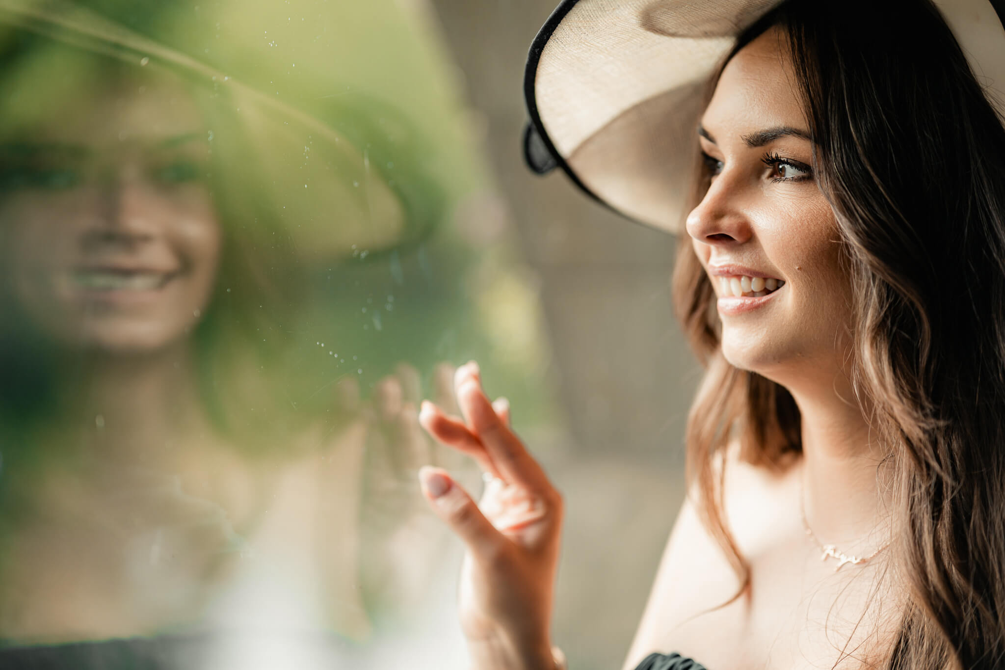 Wedding guest smiling by window with reflection