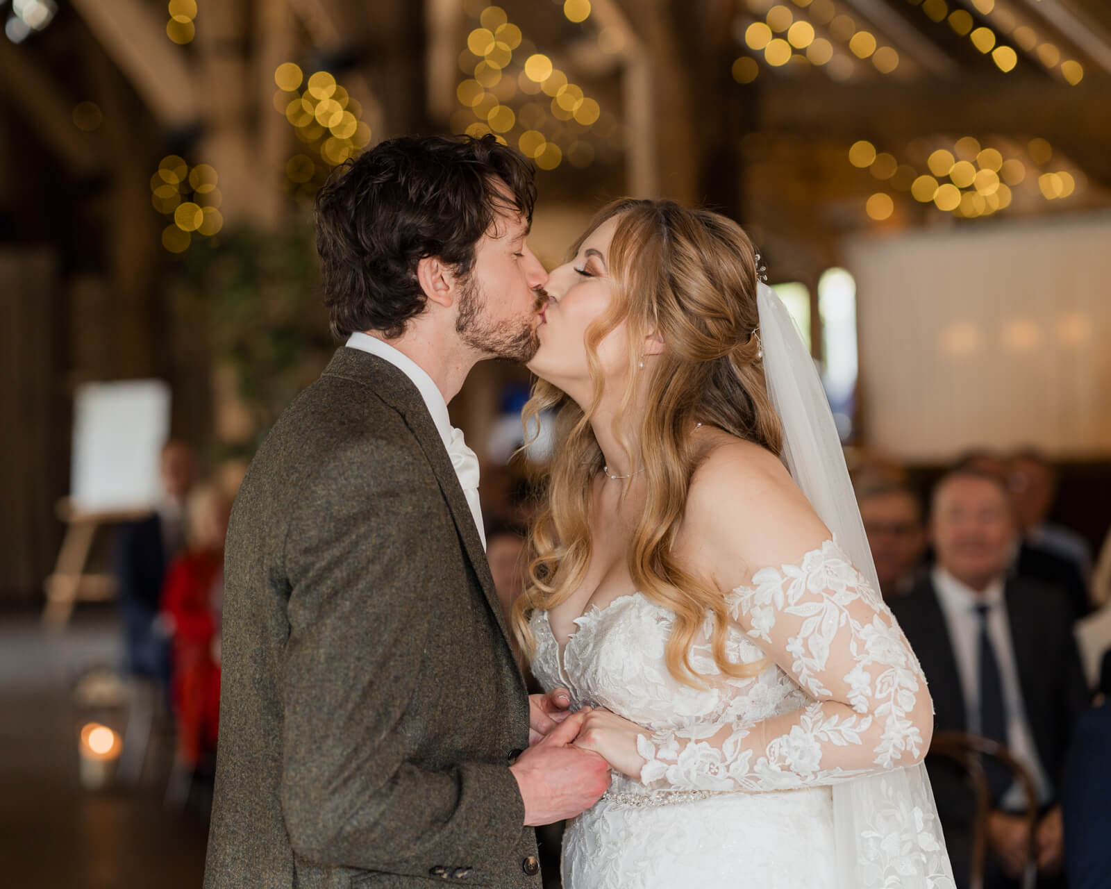 Bride and groom sharing their first kiss during wedding ceremony