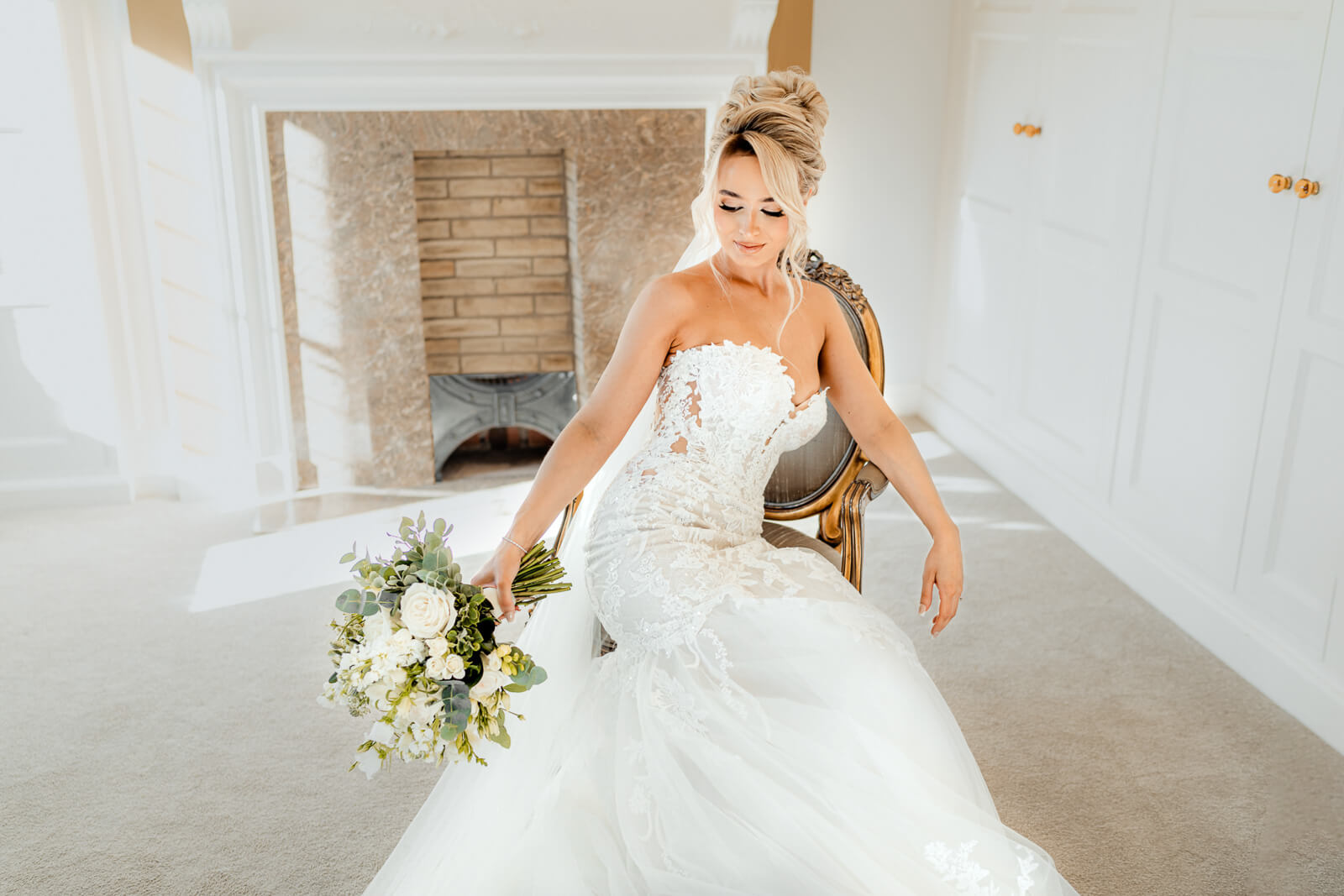 The bride walks forward holding her bouquet, captured in soft natural light with elegant details at Colshaw Hall Country Estate.