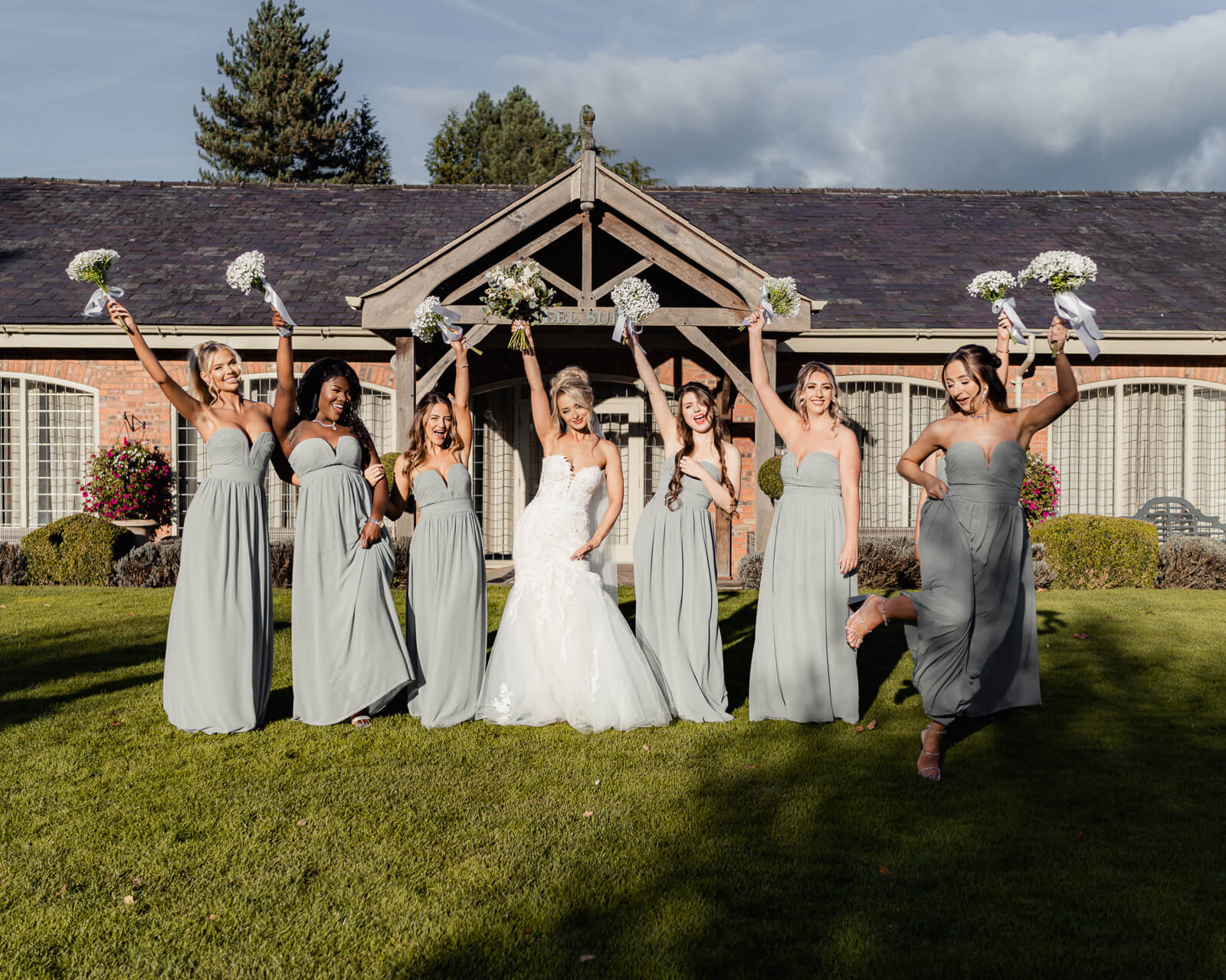 Bride and bridesmaids celebrating with bouquets during Elegant Wedding at Colshaw Hall Country Estate