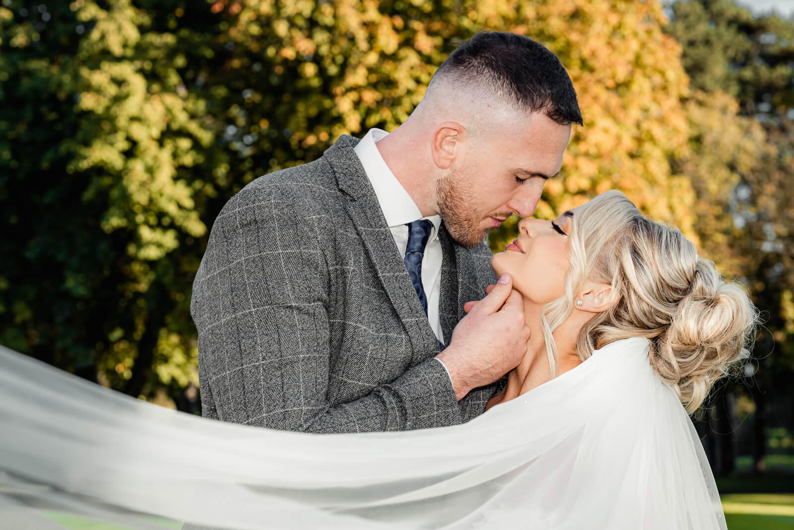 Bride and groom sharing a romantic moment with veil during Elegant Wedding at Colshaw Hall Country Estate