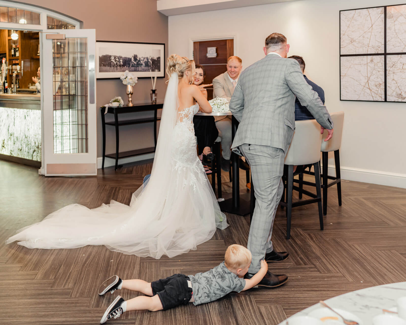 Young child playfully holding groom’s leg during Elegant Wedding at Colshaw Hall Country Estate reception