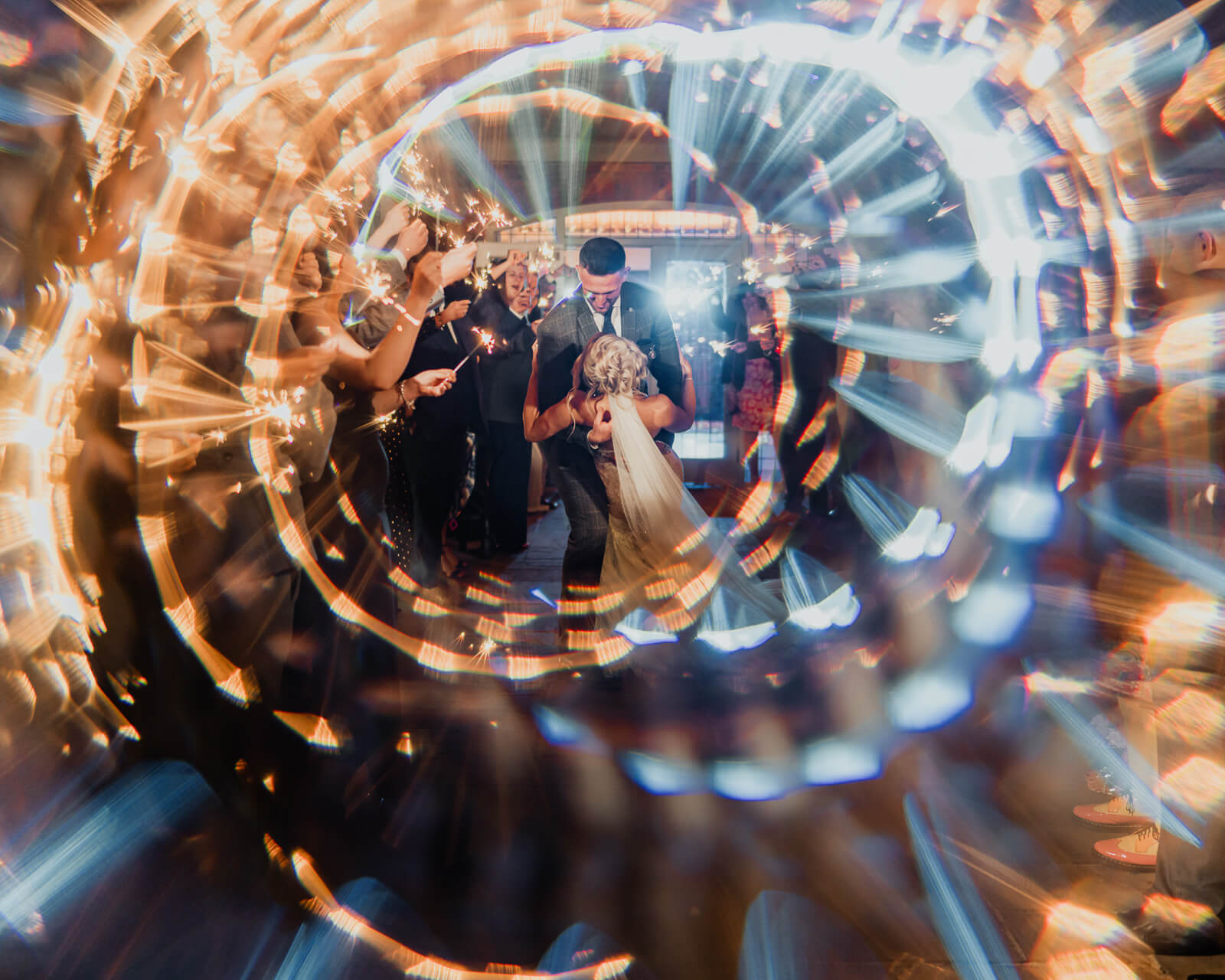 Bride and groom during sparkler exit at Elegant Wedding at Colshaw Hall Country Estate with creative light effects and guests