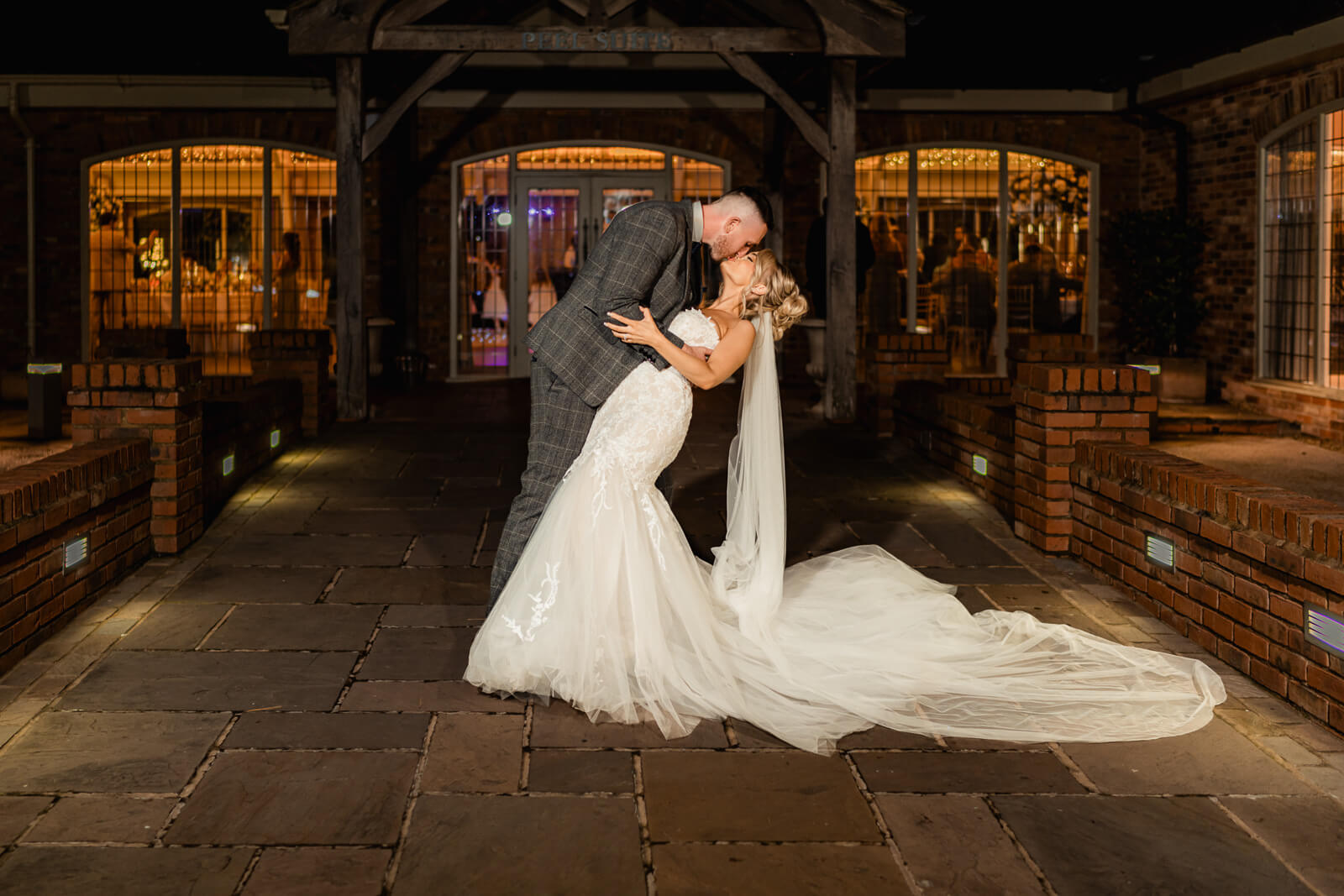Bride and groom sharing a romantic dip kiss outside at Elegant Wedding at Colshaw Hall Country Estate at night