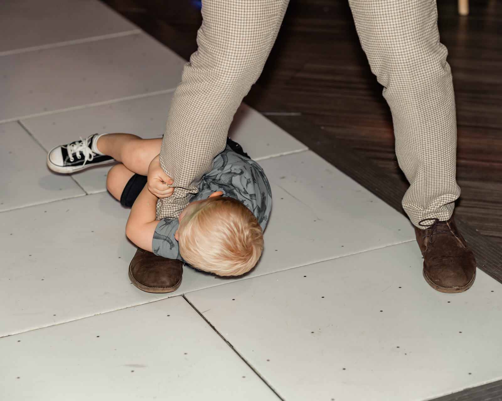 Child playfully holding onto guest’s leg on dance floor during Elegant Wedding at Colshaw Hall Country Estate reception