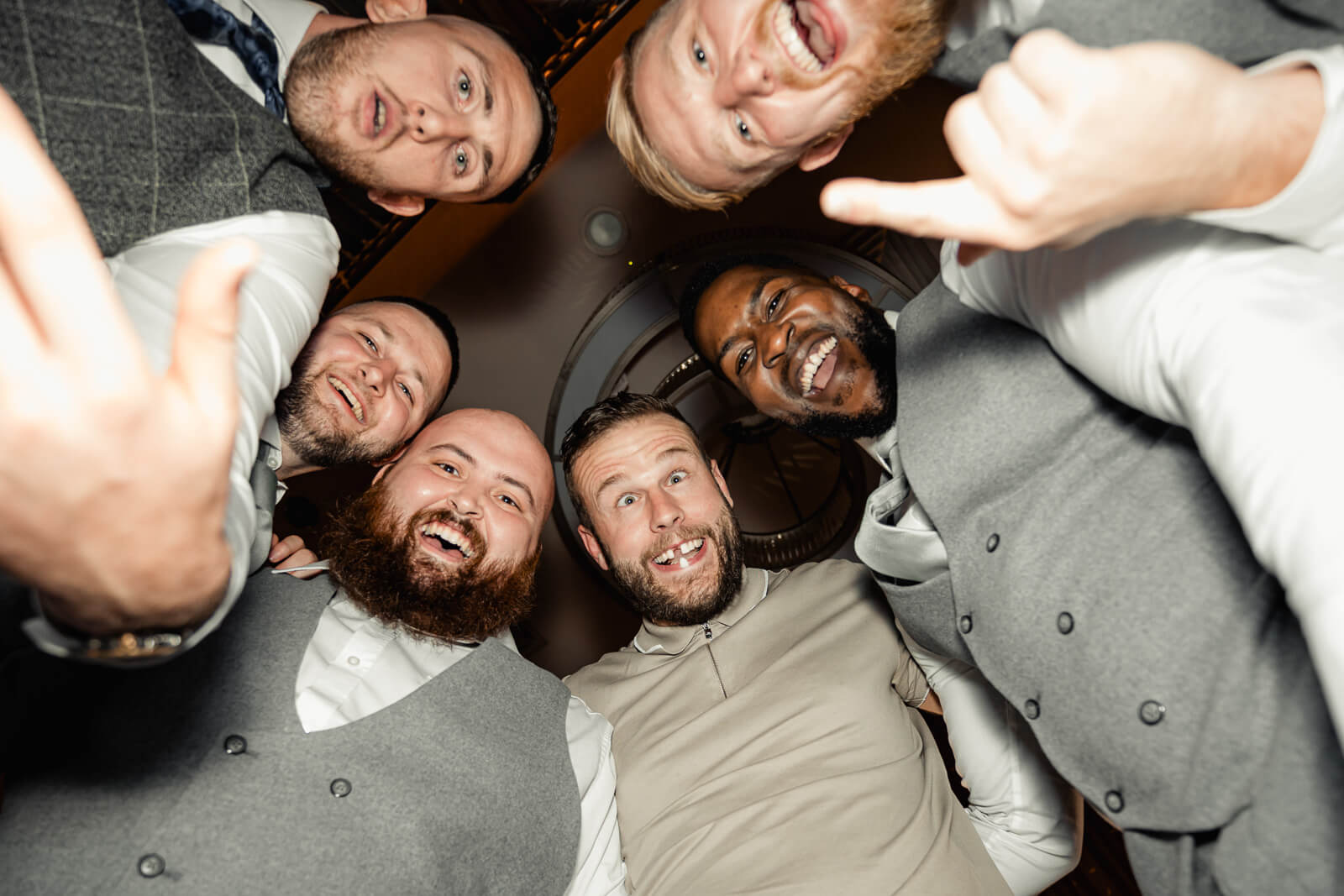 Groomsmen laughing in a circle during reception at Elegant Wedding at Colshaw Hall Country Estate in Cheshire