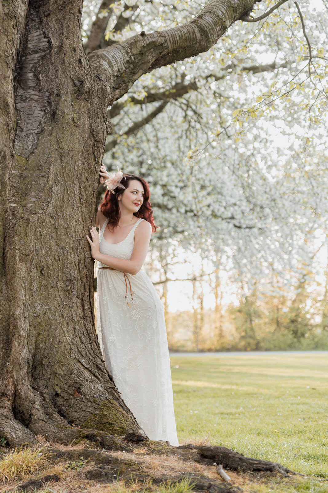 Woman standing by a tree with blossoms in Harrogate during a spring photo session