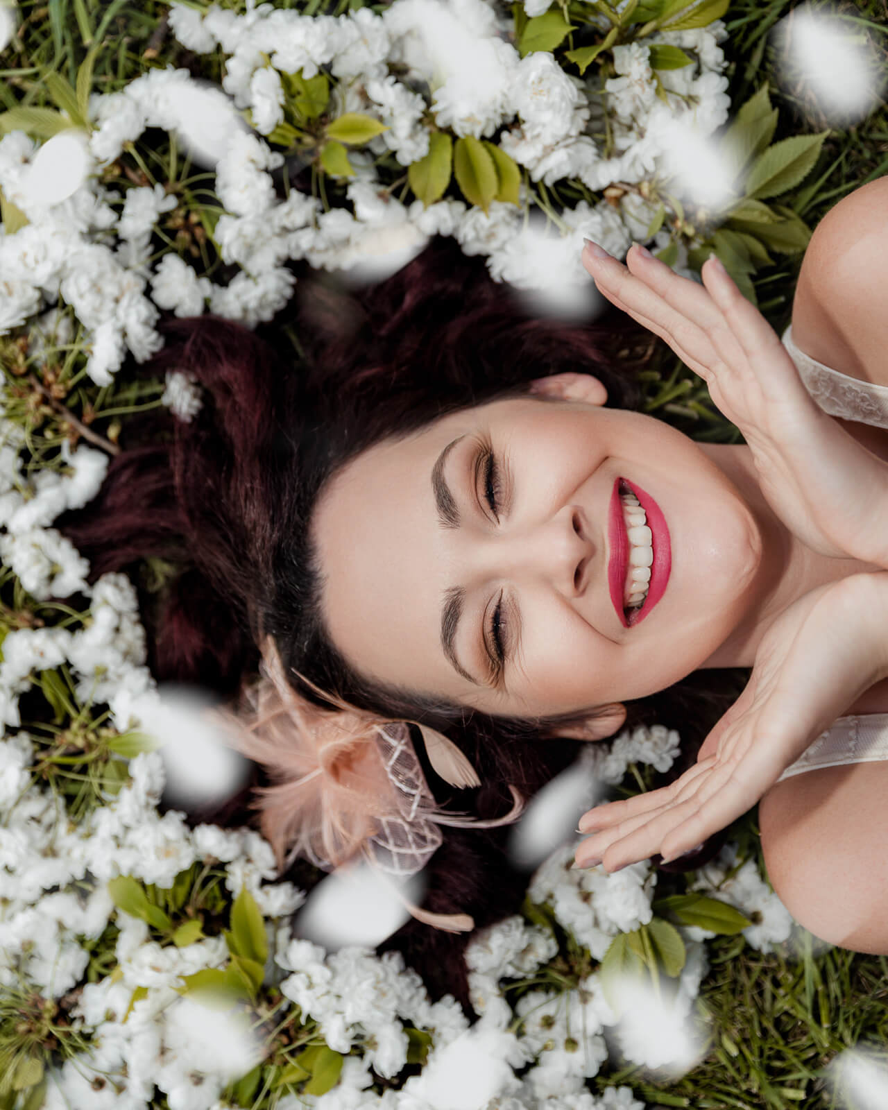 Woman lying among cherry blossom flowers in Harrogate during a spring photo session