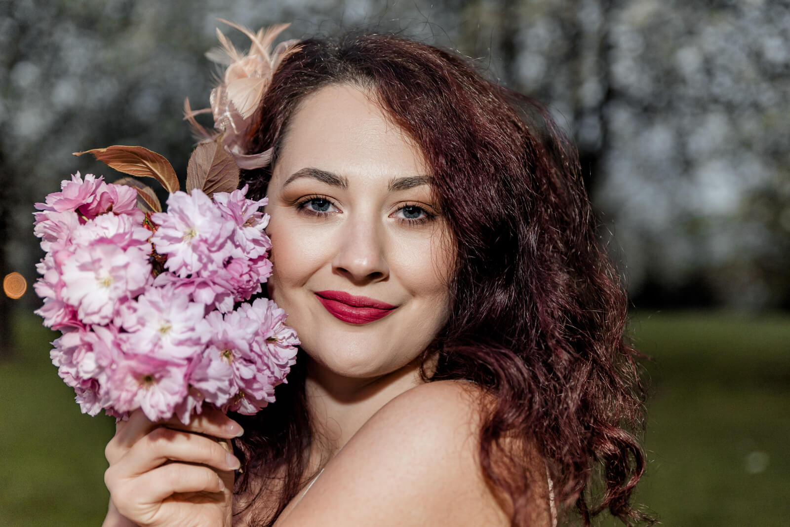 Close-up portrait of a woman holding cherry blossoms in Harrogate during a spring session