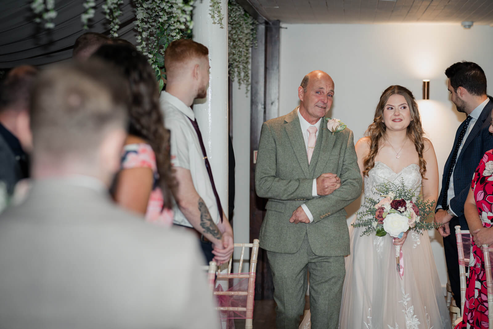 Bride walking down the aisle with her father during wedding ceremony at Chevin Country Park
