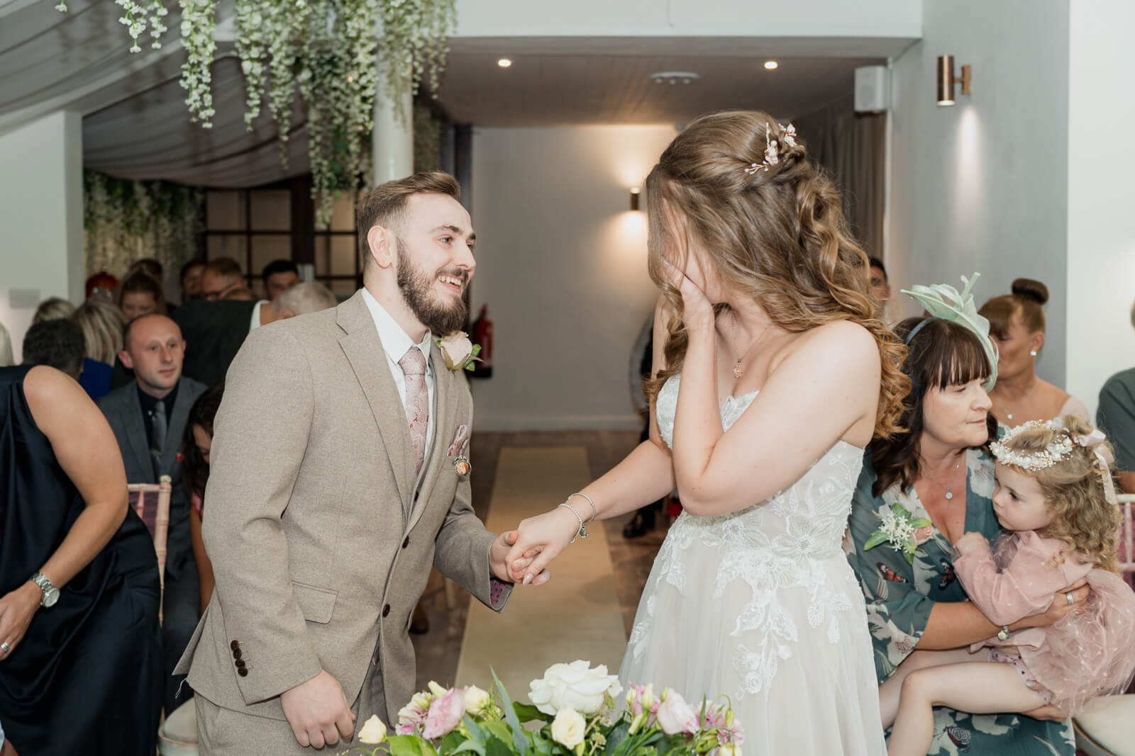 Groom holding bride’s hand as she reacts emotionally during ceremony at Chevin Country Park