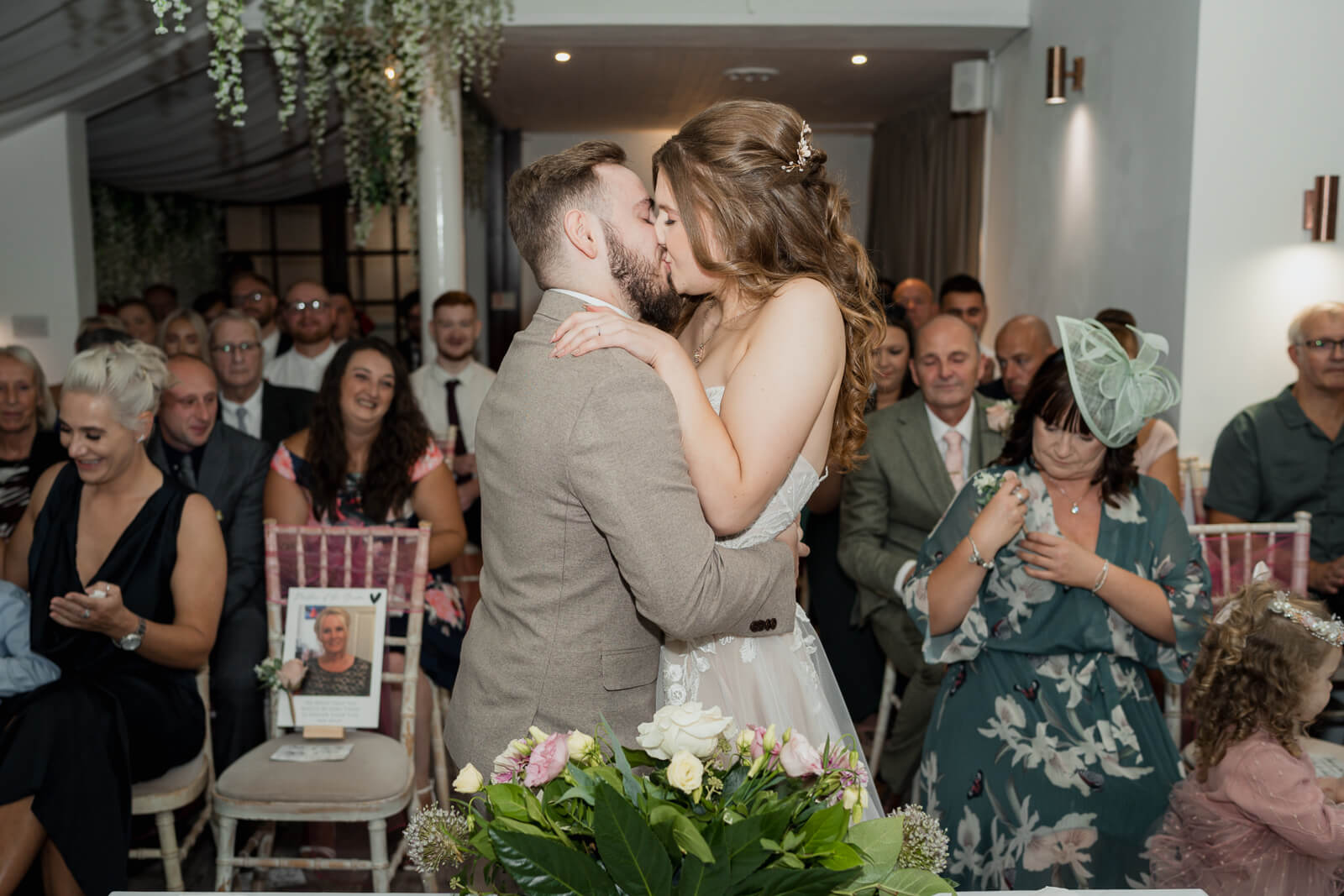Bride and groom sharing their first kiss during wedding ceremony at Chevin Country Park