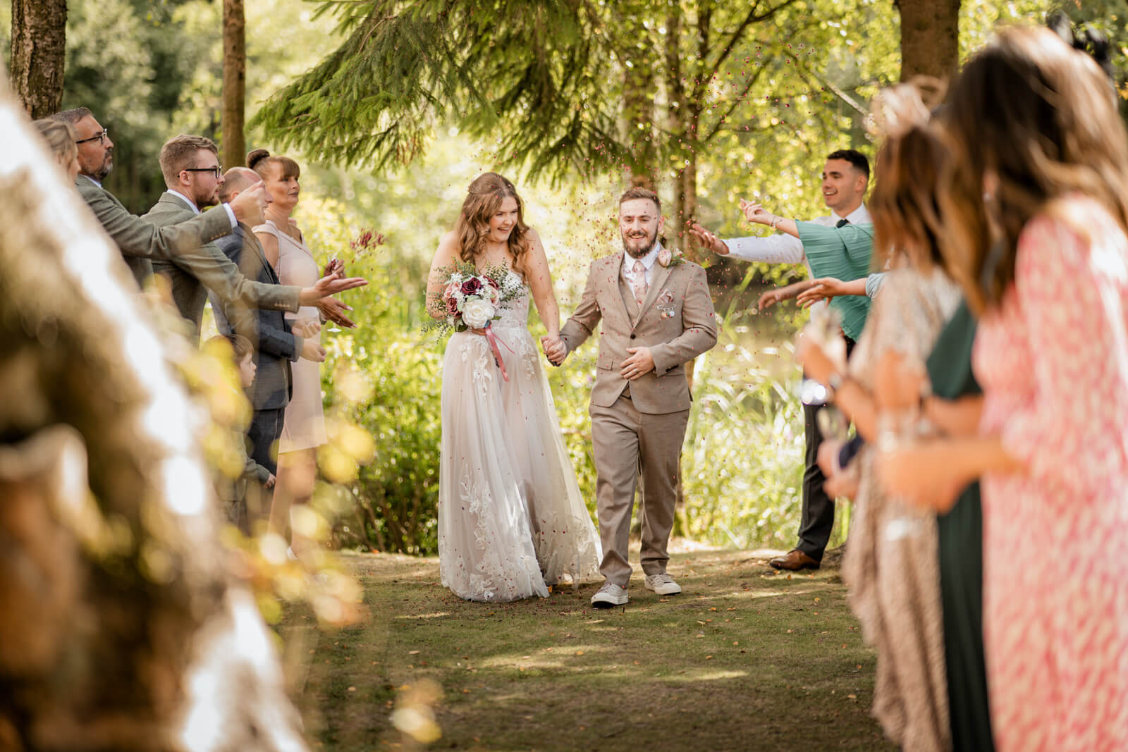 Bride and groom walking through confetti after ceremony at Chevin Country Park