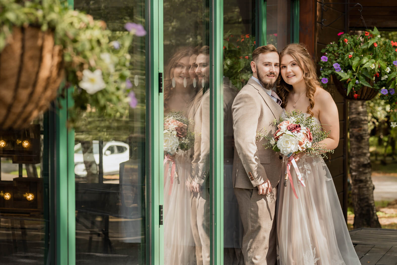 Bride and groom portrait by glass doors at Chevin Country Park
