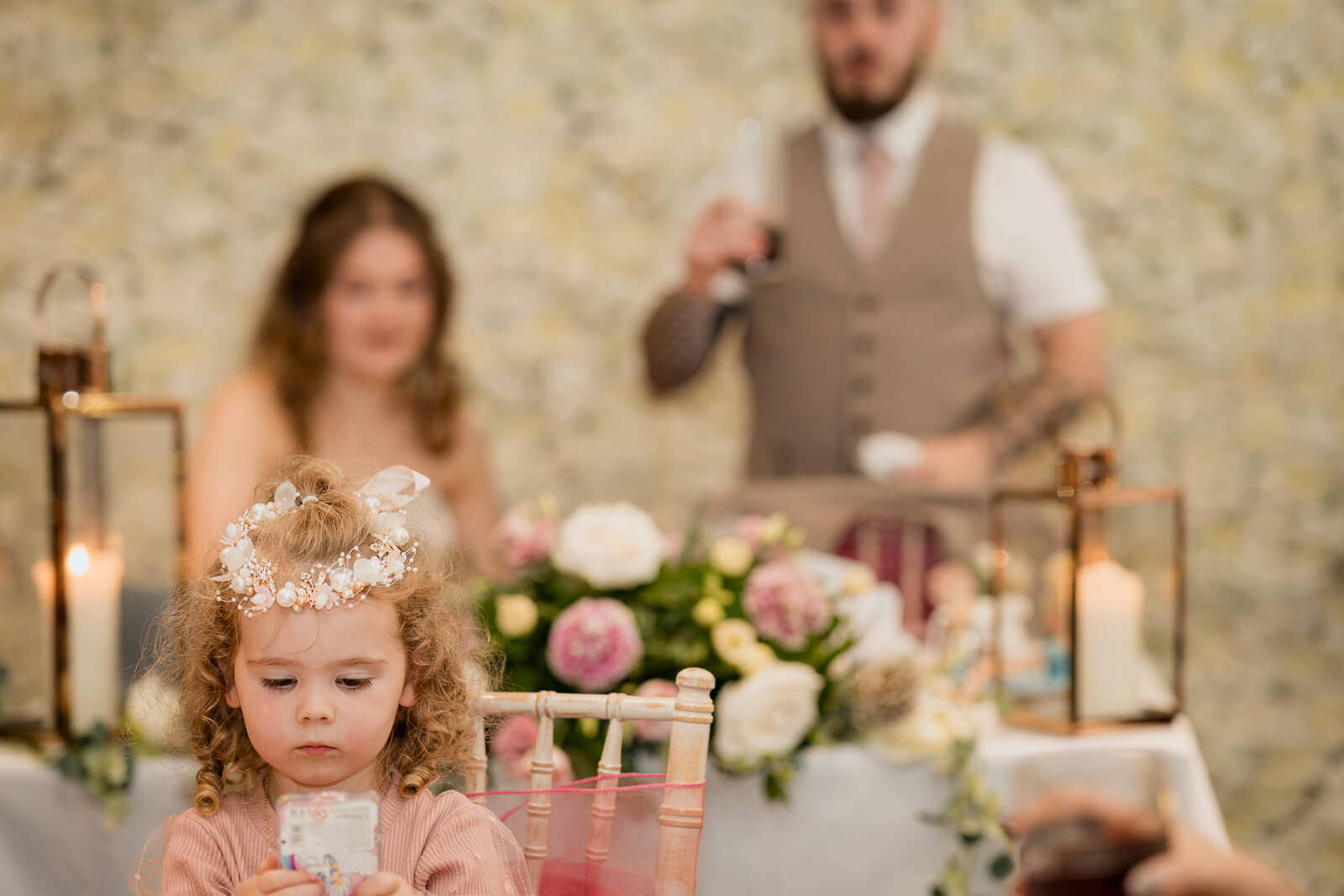 Flower girl sitting at table during wedding reception at Chevin Country Park