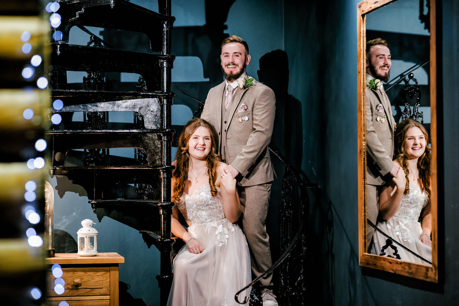 Bride and groom posing on spiral staircase with mirror reflection at Chevin Country Park