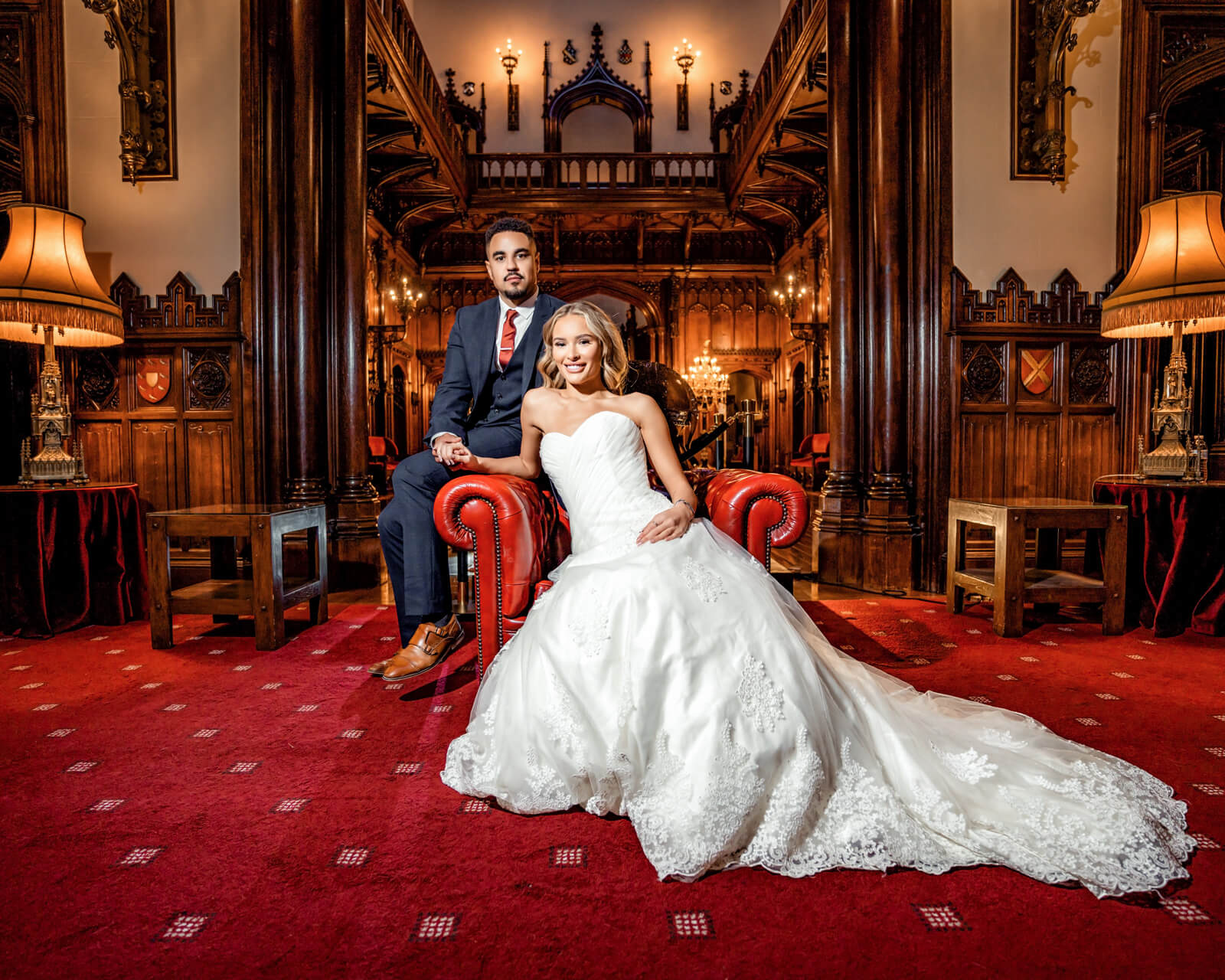 editorial wedding couple portrait seated in elegant interior with warm lighting