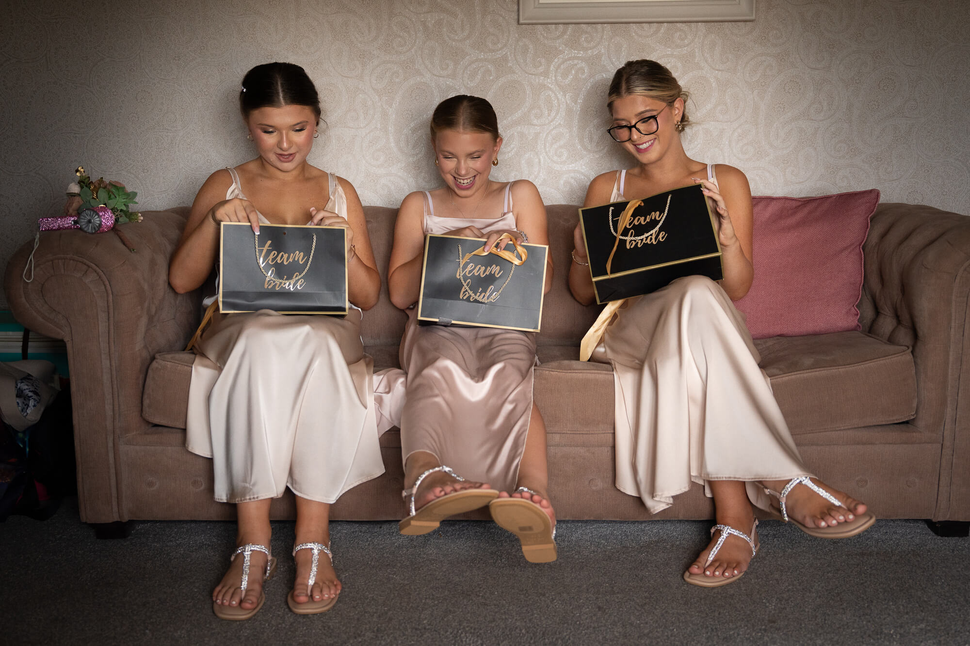 Bridesmaids opening their wedding gift boxes before the ceremony.